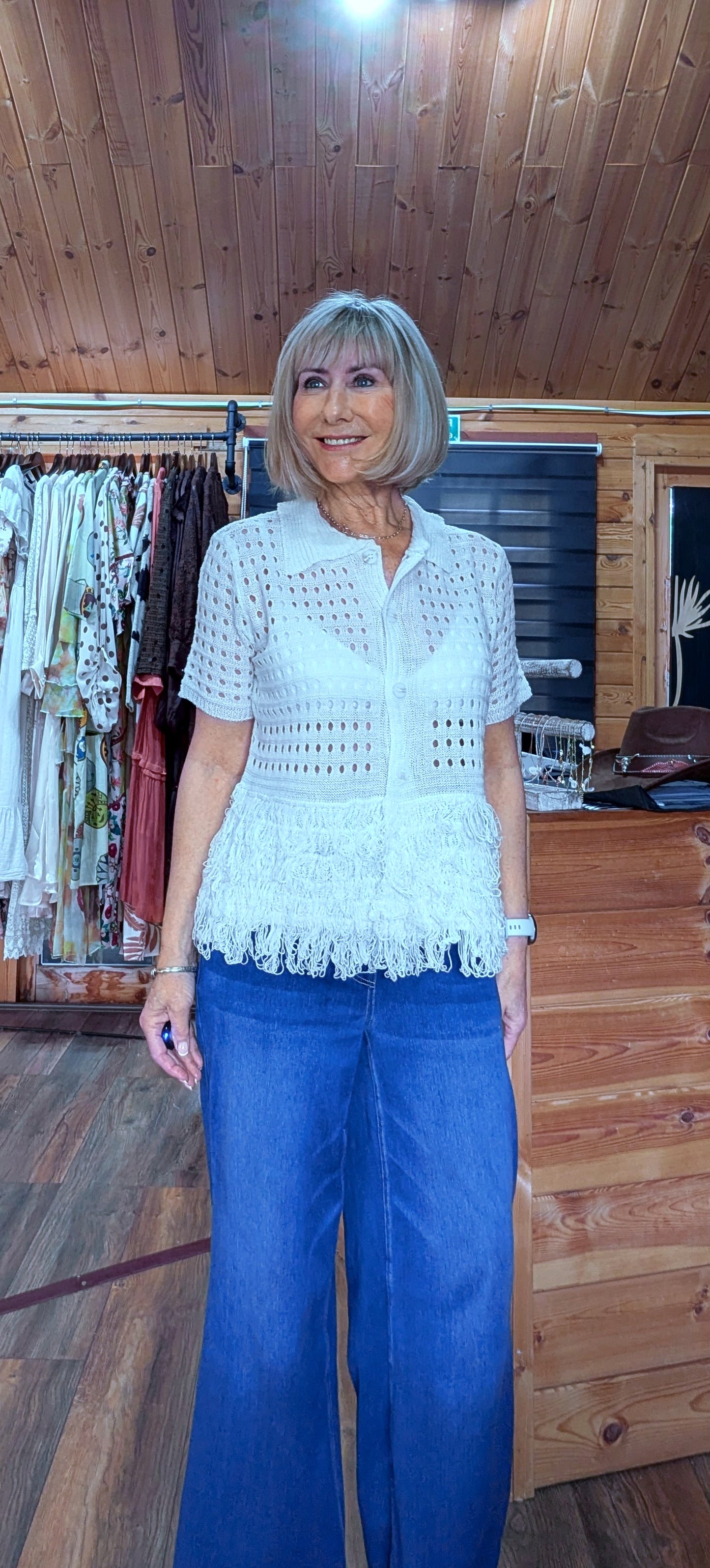Close up of cream crochet top with fringe detail