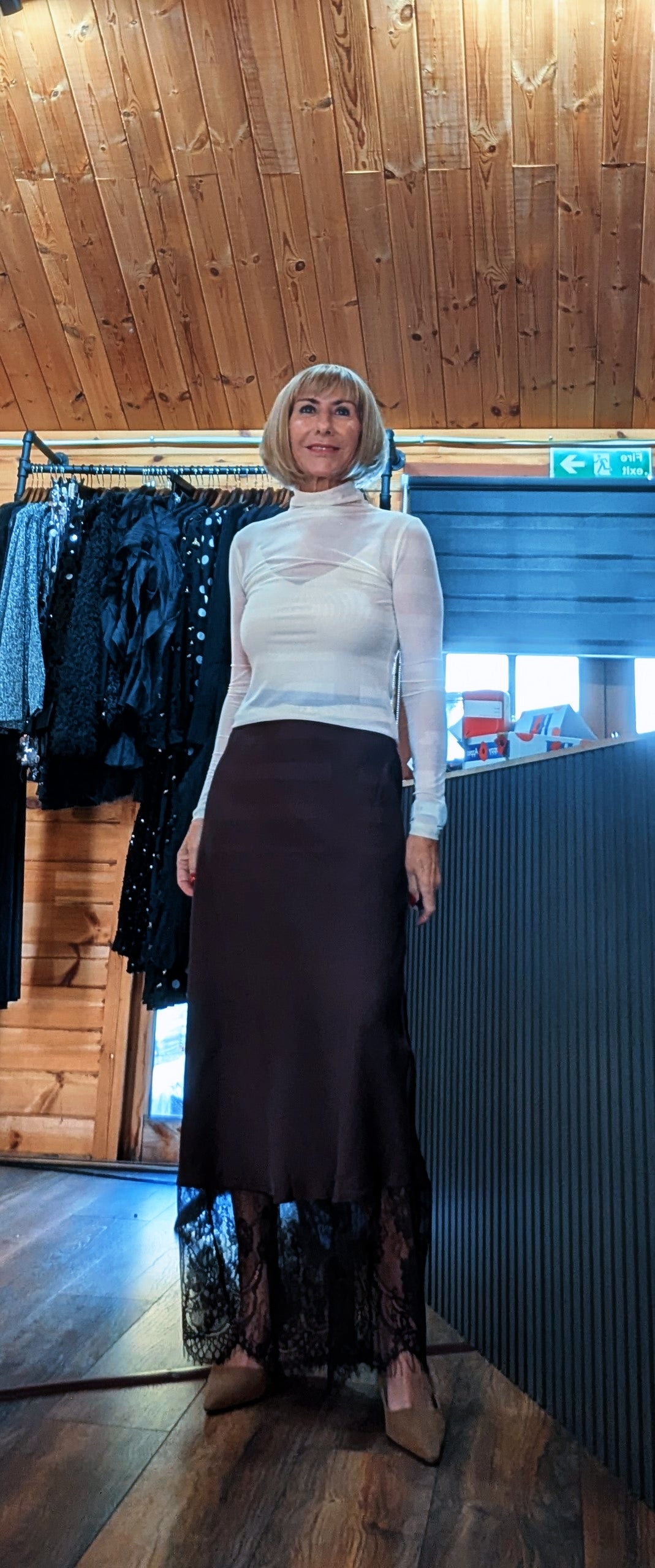 Front view of Di modelling the Lumine skirt, showing the sheer floral lace panel at the hem