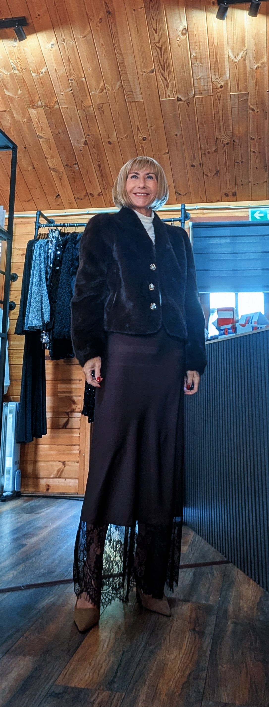 Front view of Di wearing the Lumine slip skirt with the Bessie chocolate faux fur jacket