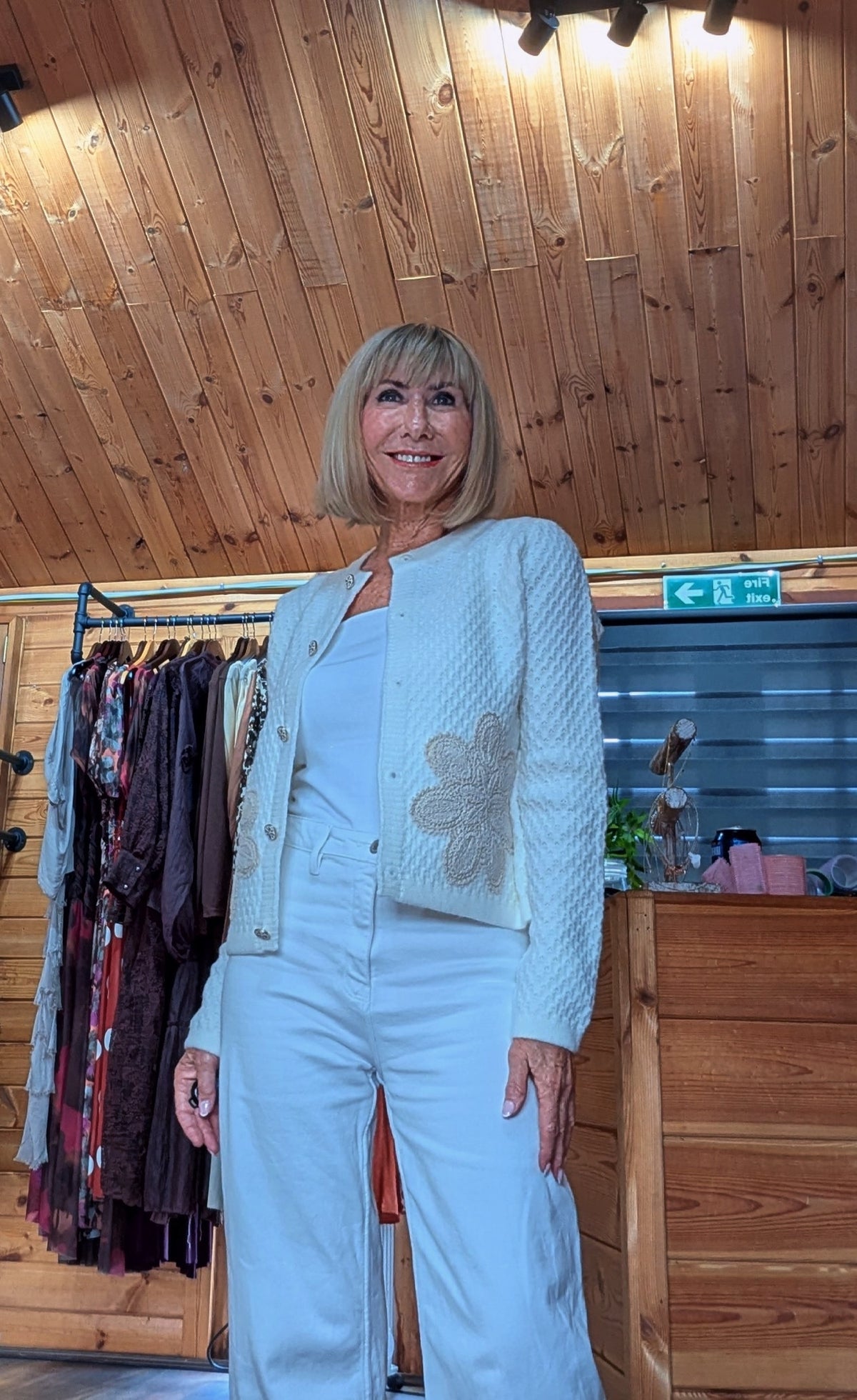 Women’s ivory knitted cardigan with decorative buttons and floral front detail.