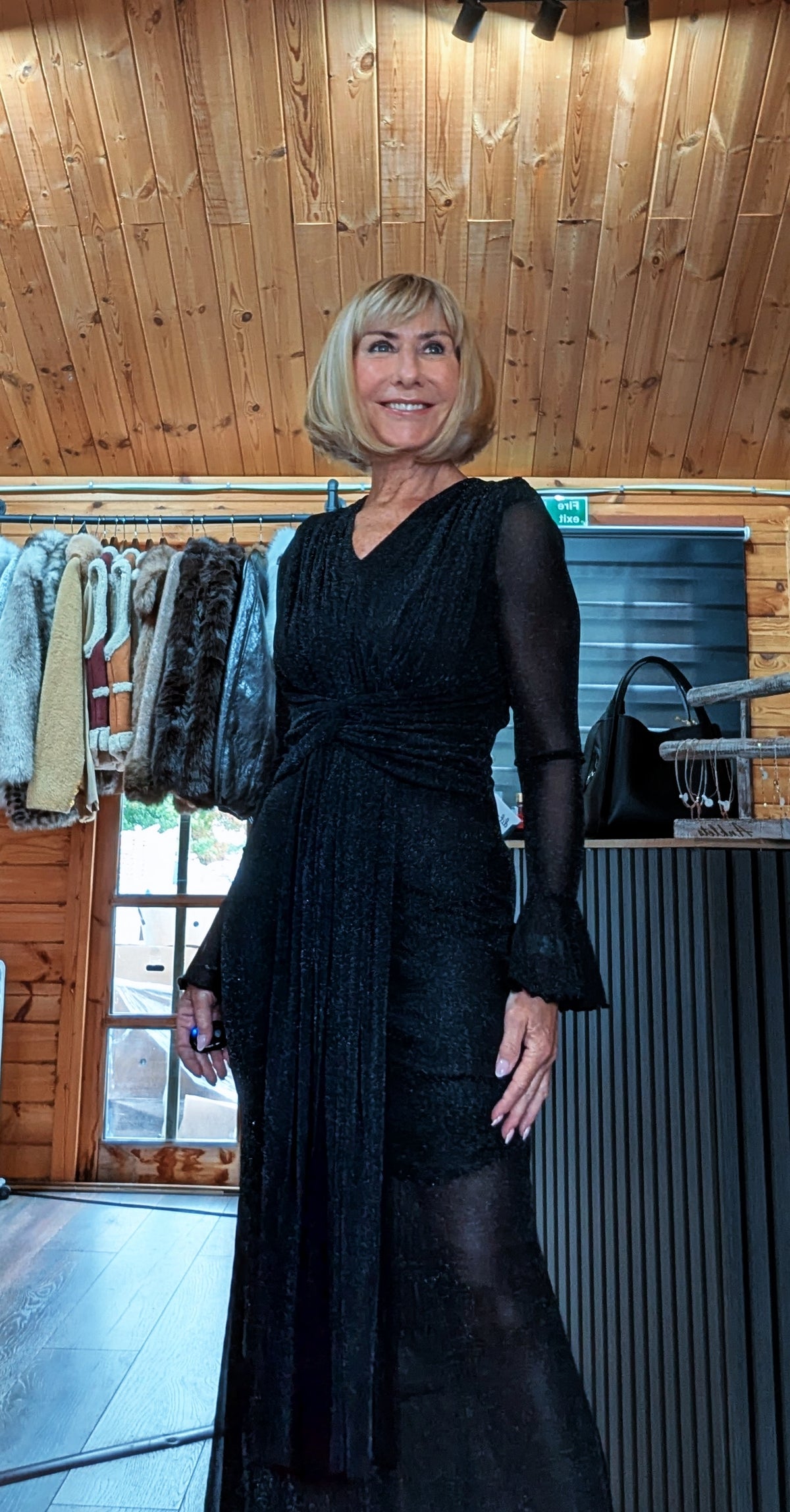 Three-quarter view of Shirley glitter mesh dress showing the waist gathering and flared cuffs