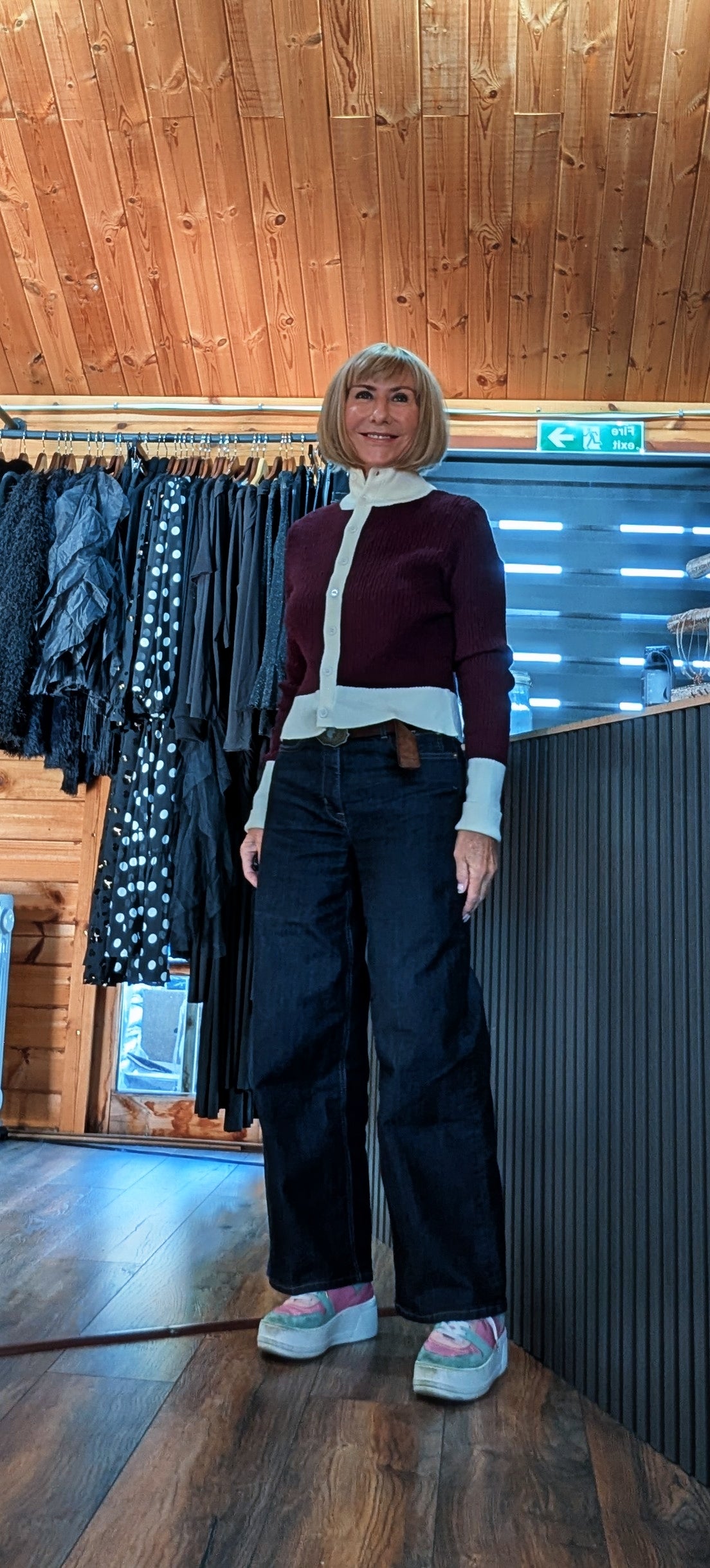 Mallory contrast-trim cardigan shown from the front with wide-leg jeans and trainers