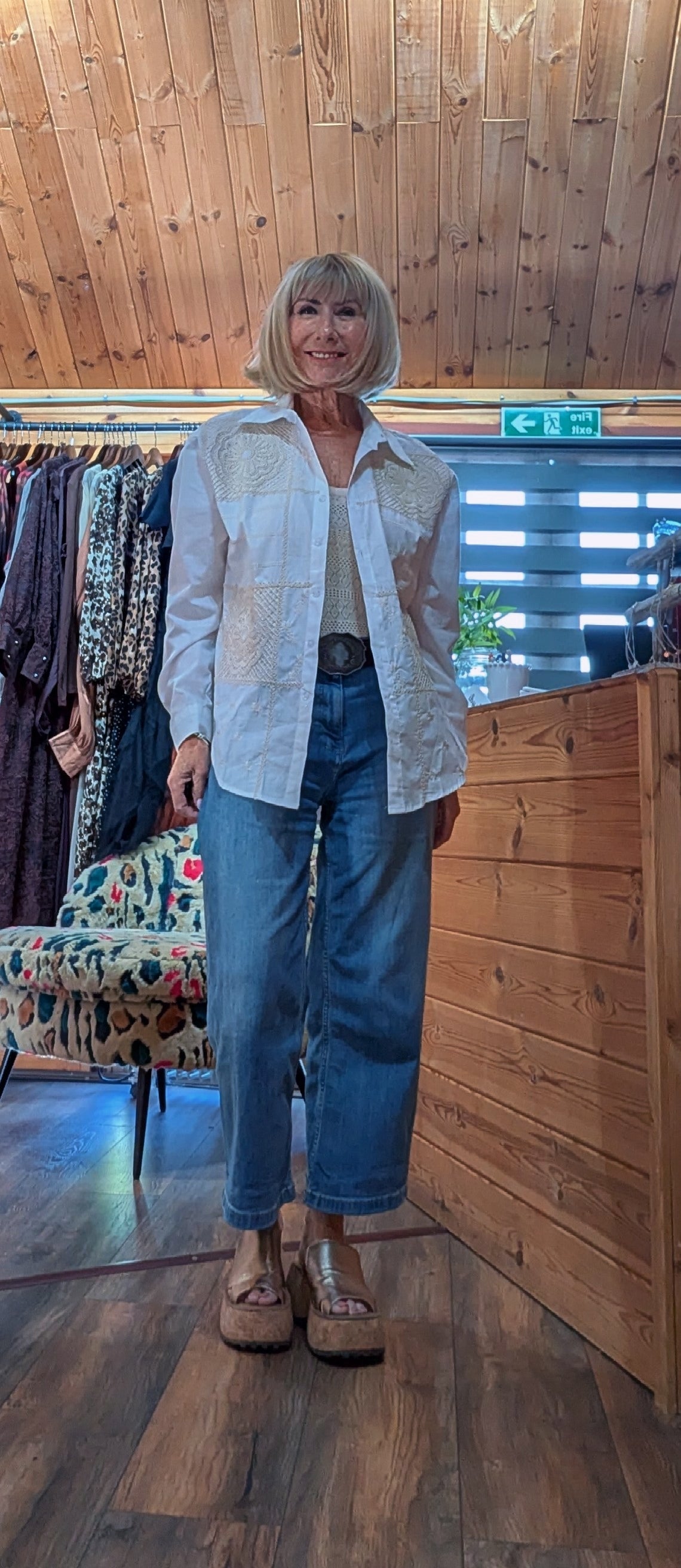 ditsydi boutique ditsydi wearing Dora white embroidered button-up shirt, blue jeans, and brown platform sandals. 
