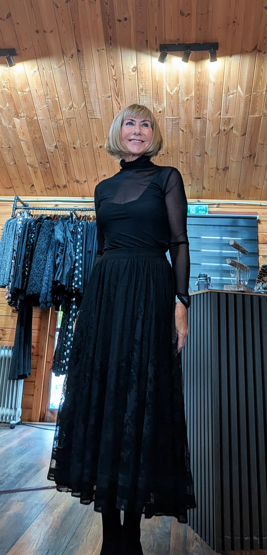 Di wearing the Erin black lace midi skirt with a black sheer top