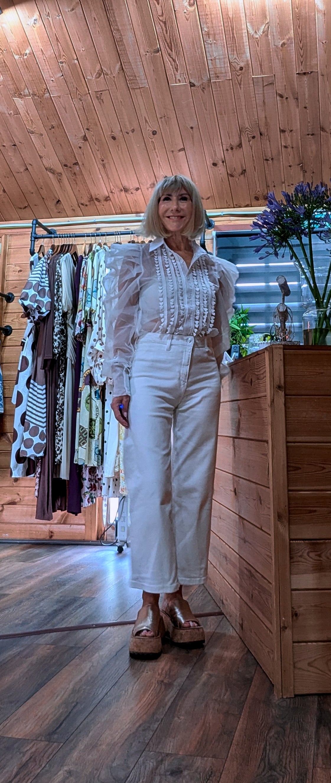 Lucille feminine occasion blouse featuring sheer long sleeves and gathered cuffs.