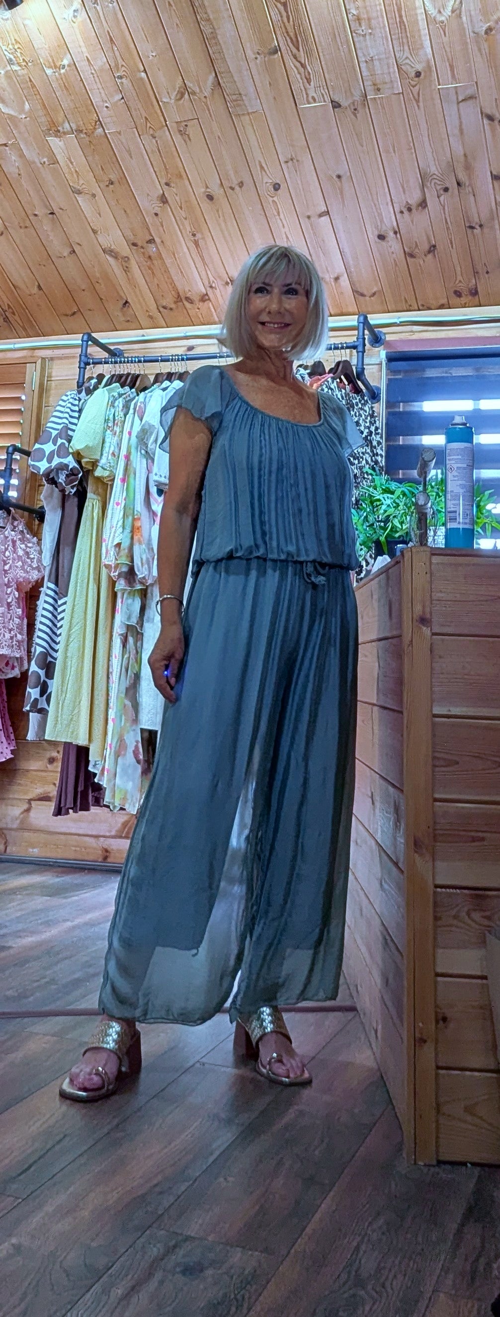 Jess aqua silk blend jumpsuit featuring an elasticated neckline that can be worn on or off the shoulder, with a flattering tie waist and wide-leg fit. One size fits UK 8–14.