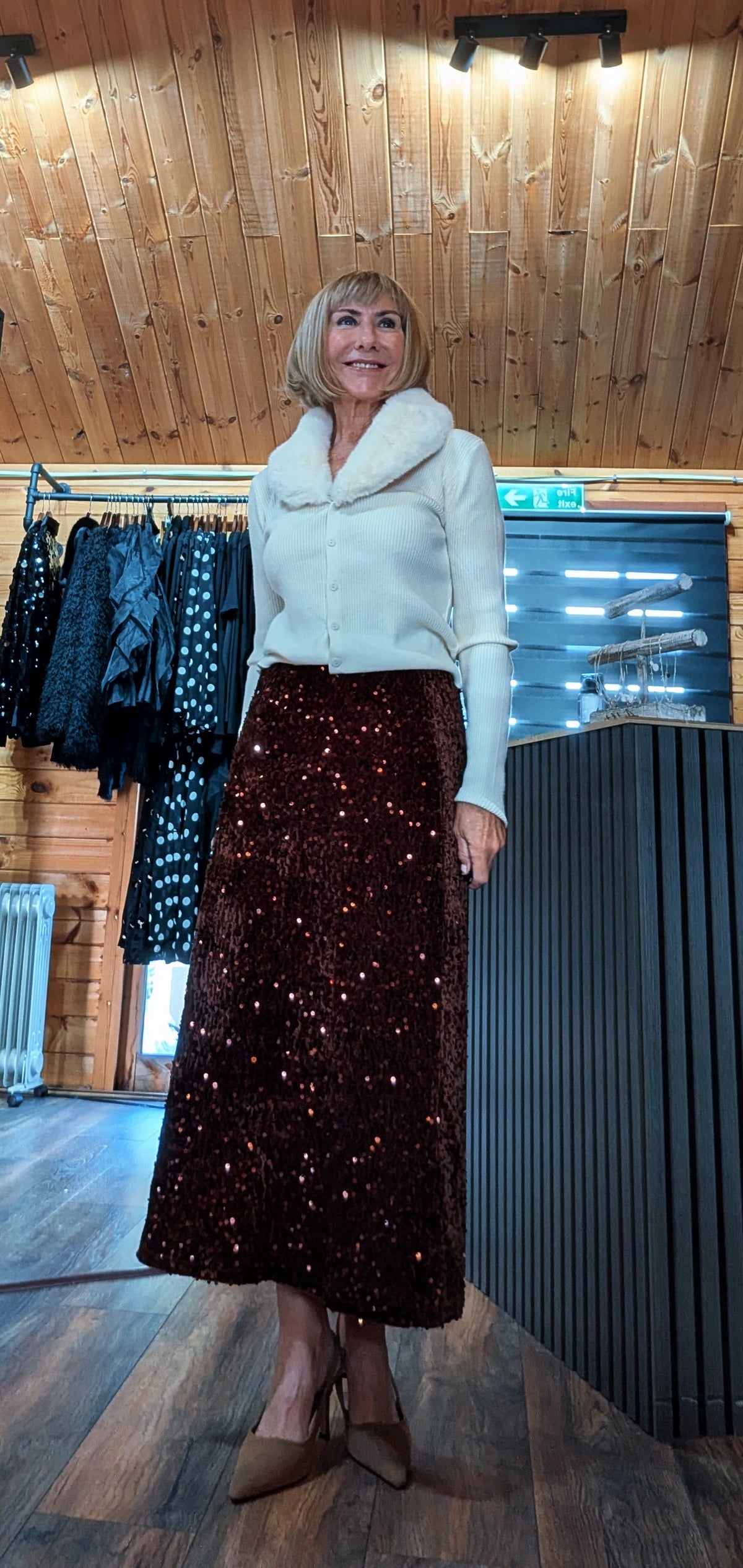 Astrid chocolate sequin skirt worn with a cream knit top, showing the sparkling fabric