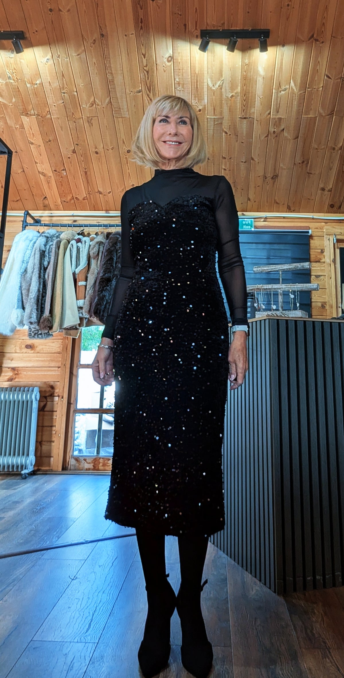 Front view of Audrey showing the sequin skirt, sheer sleeves and black boots.