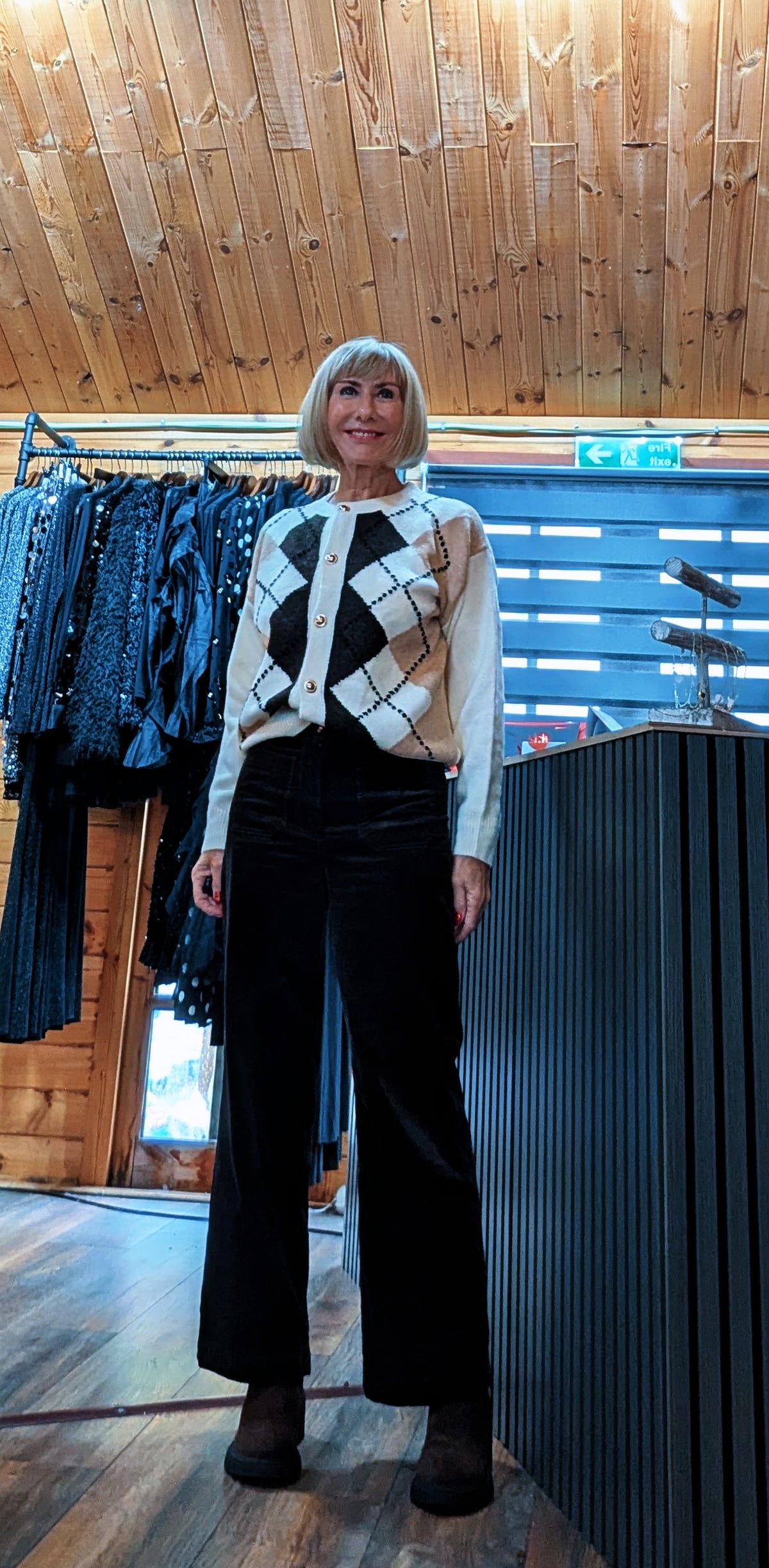 Irene argyle cardigan styled with black trousers and boots in the boutique