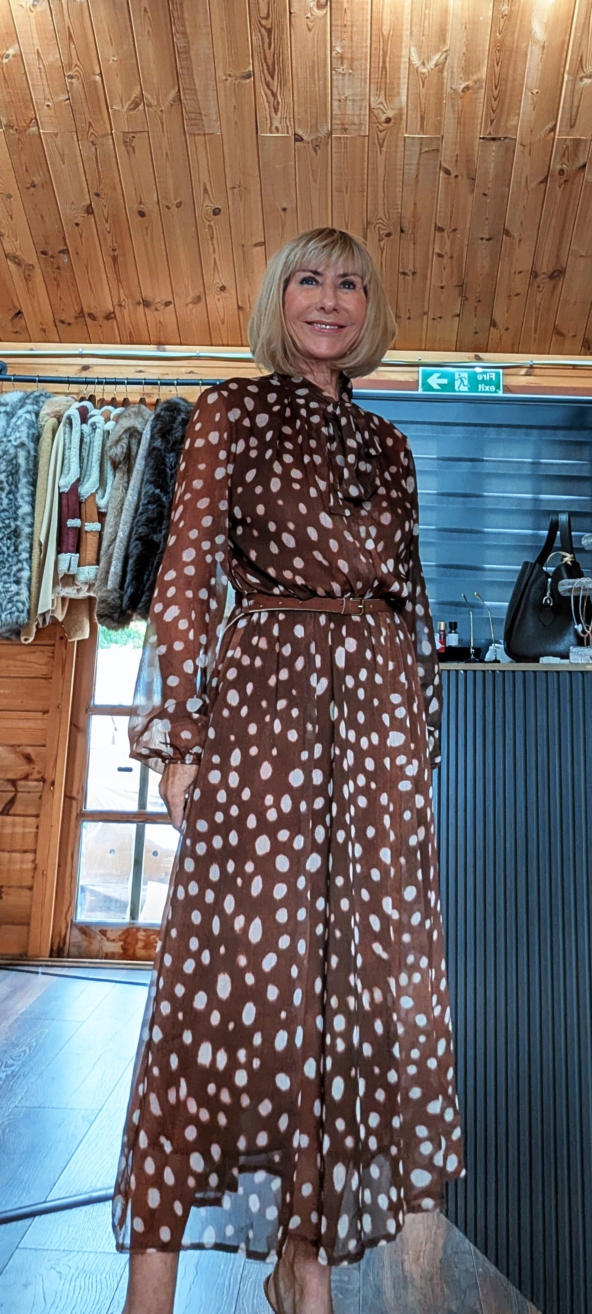 Dorothy chocolate spot-print midi dress showing the tie neckline, sheer sleeves and waist belt