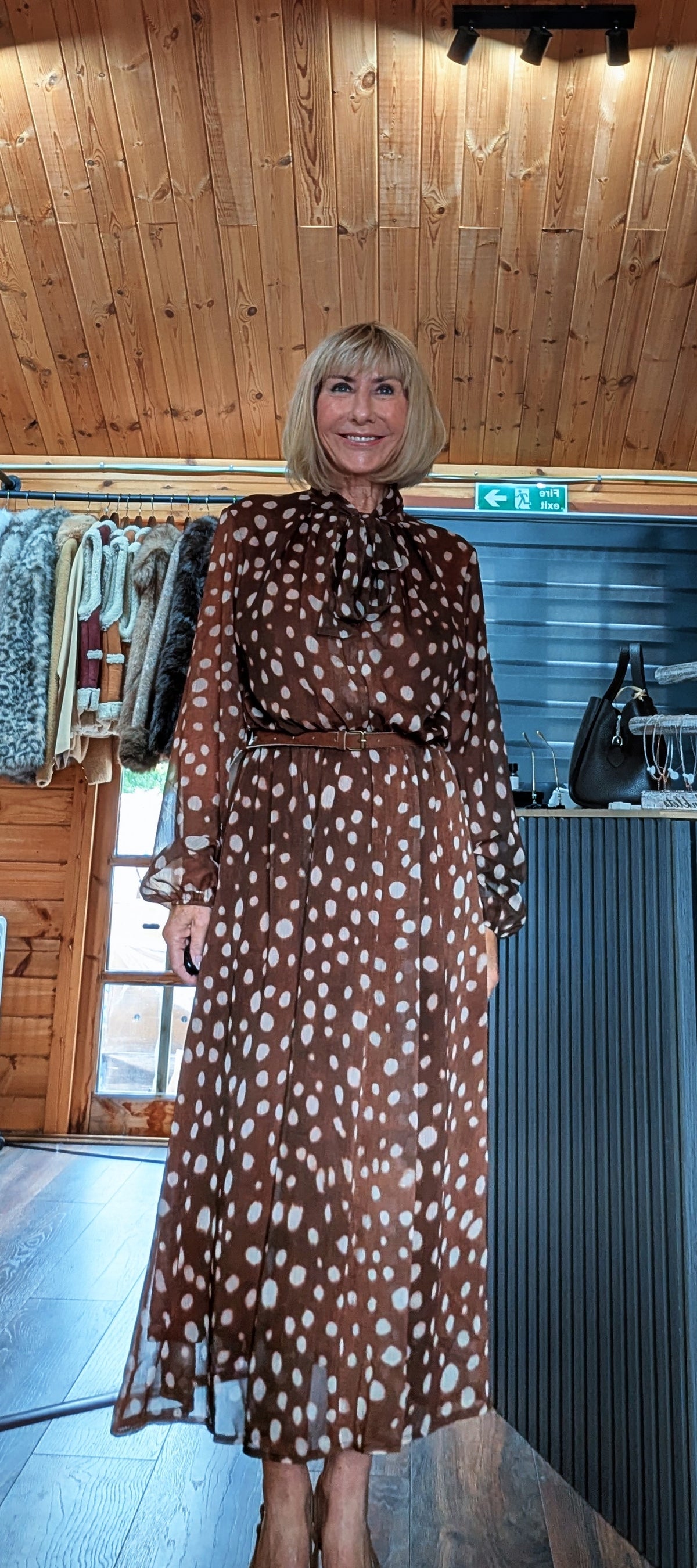 Dorothy chocolate spot-print dress modelled from the front with the bow neckline tied
