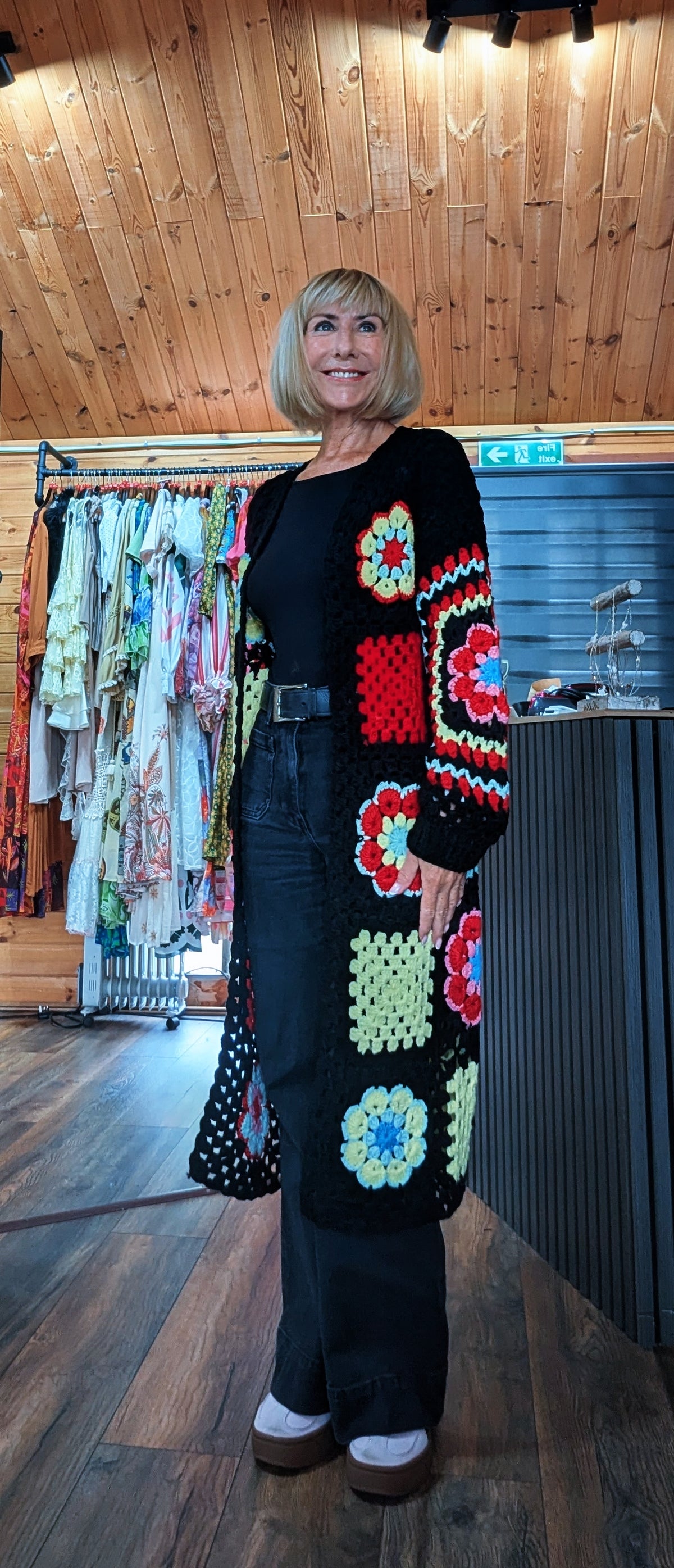 Fia women’s longline floral crochet-style cardigan in black, fitting UK sizes 8–14 styled by ditsydi with flared jeans
