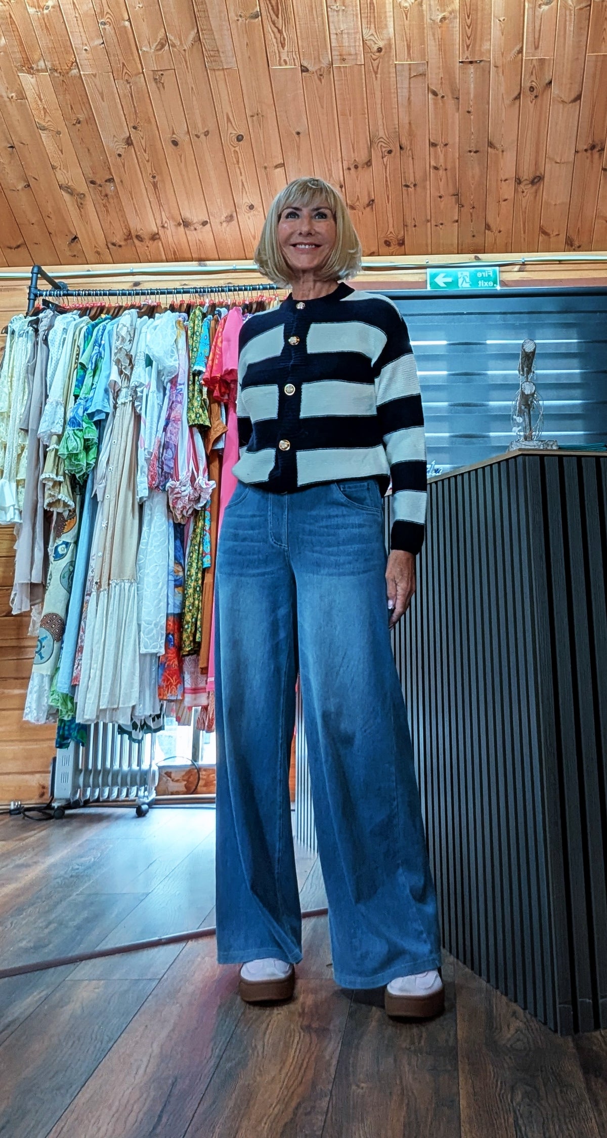 Navy blue striped cardigan with button front worn with wide flared leg jeans