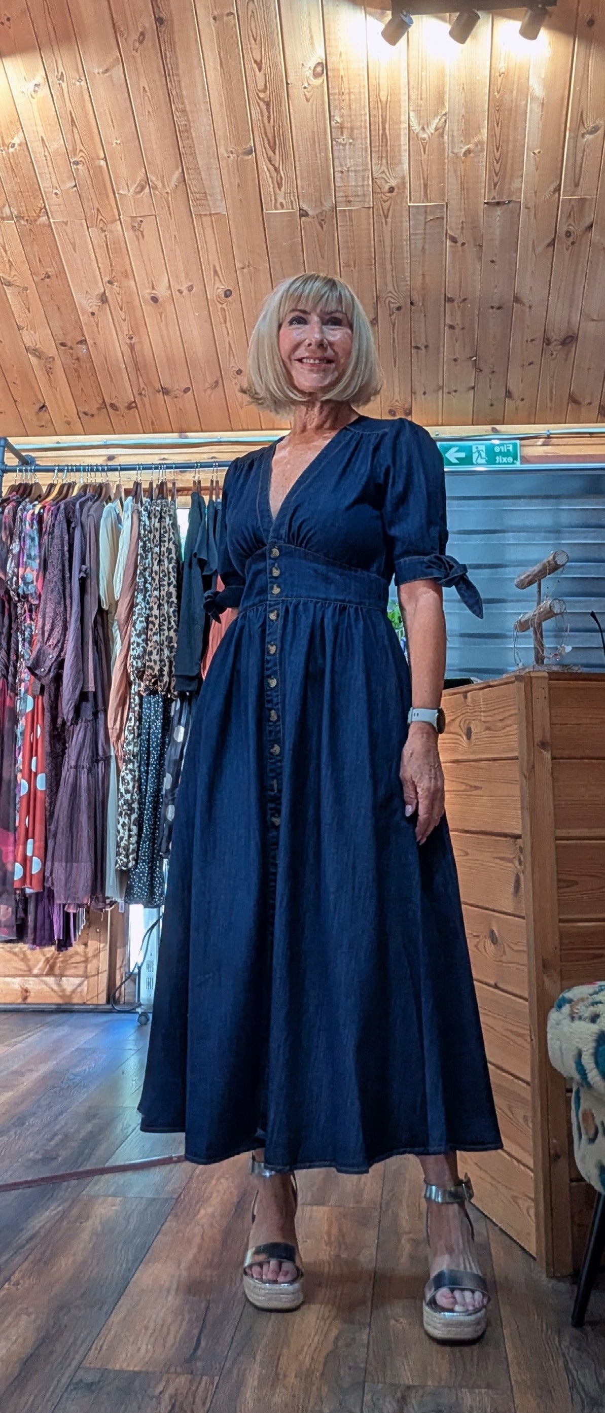 ditsydi  wearing a dark navy blue midi dress with a button-down front and tie details on the sleeves, prairie dress 