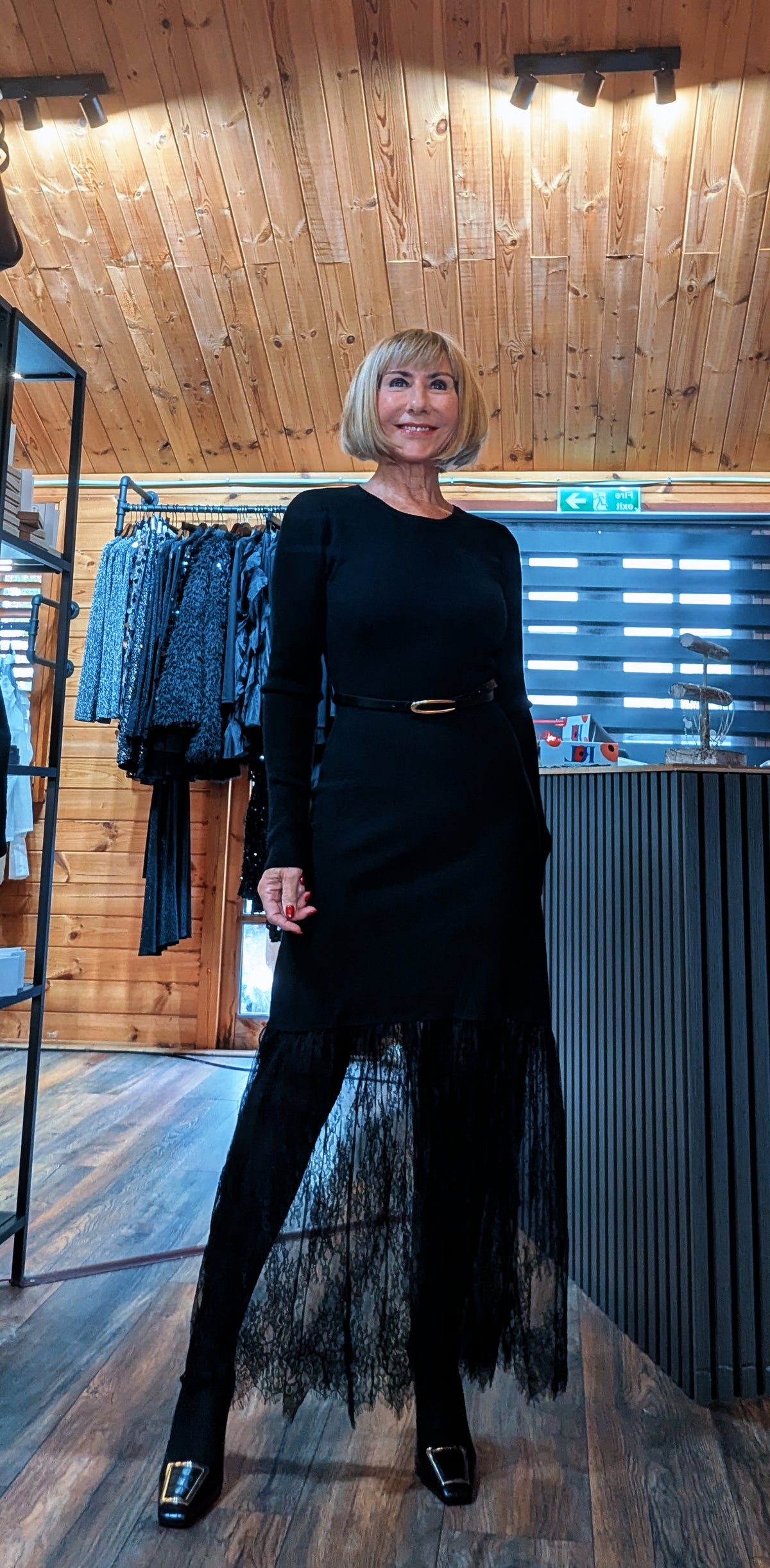 Di modelling the Aoife black belted dress with a sheer floral lace hem and black buckle shoes