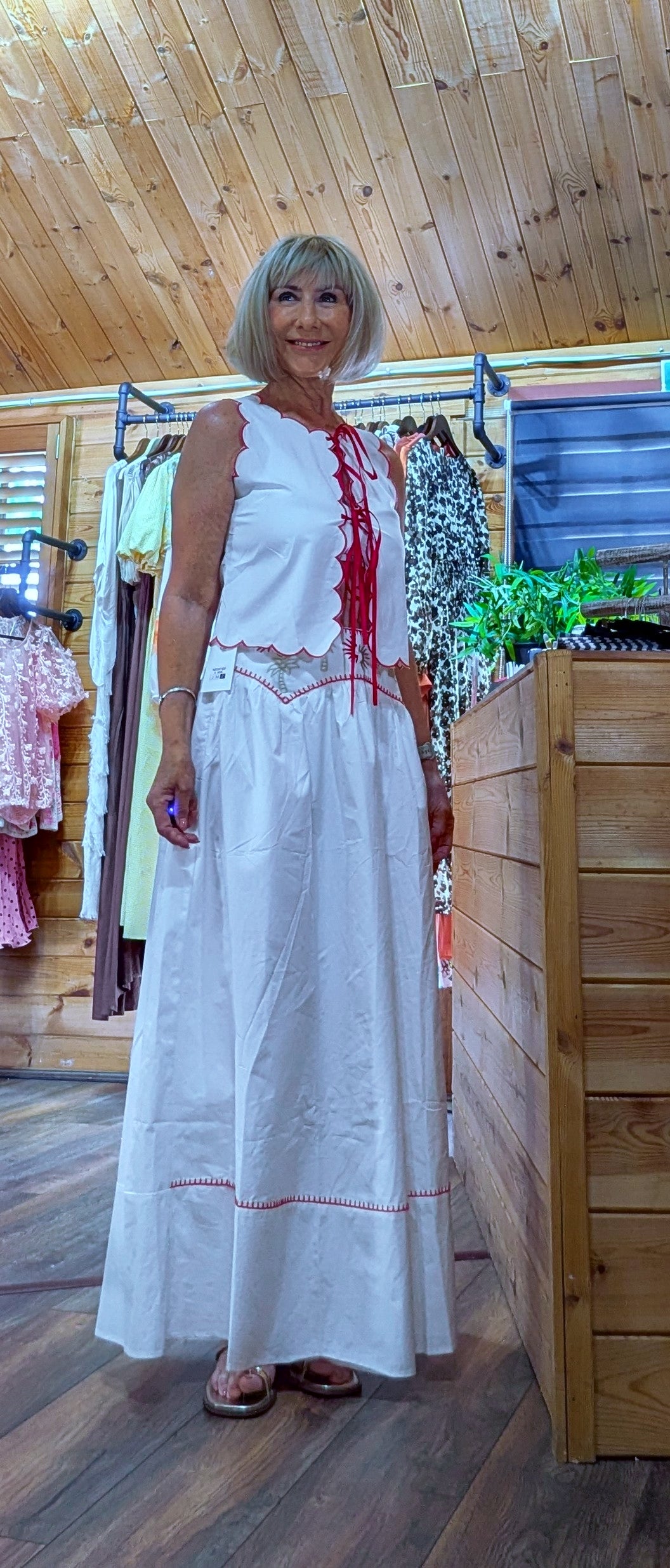 Iris white cotton top and matching maxi skirt with red embroidered detailing, scalloped edging and lace-up front. Available in sizes UK 8, 10 and 12.