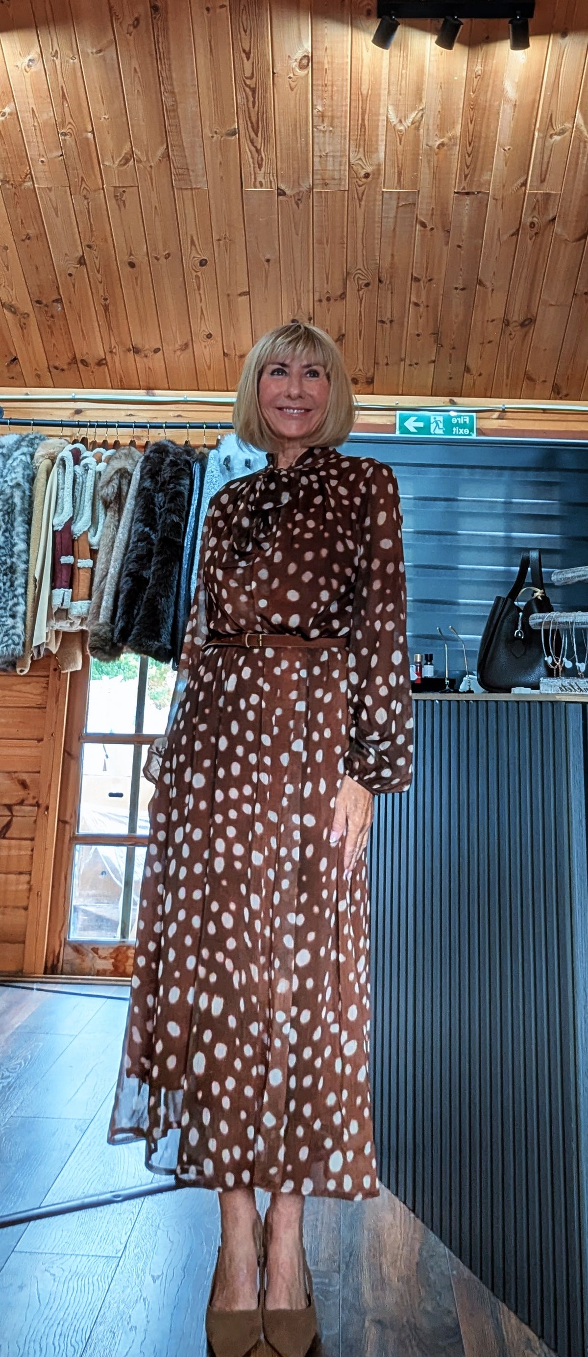Three-quarter outfit view of Dorothy spot-print midi dress with sheer sleeves and a tied neckline
