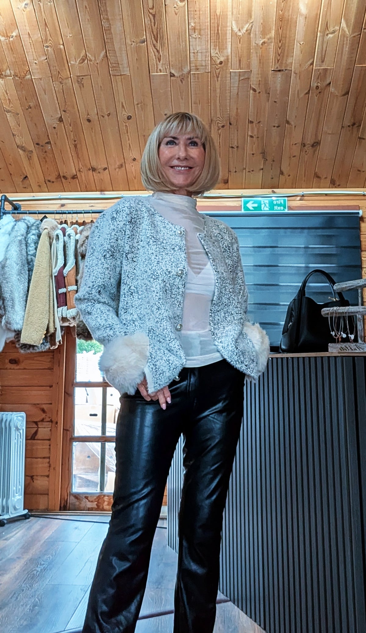 Angled view of Liv white cardigan worn open over a light top with black trousers