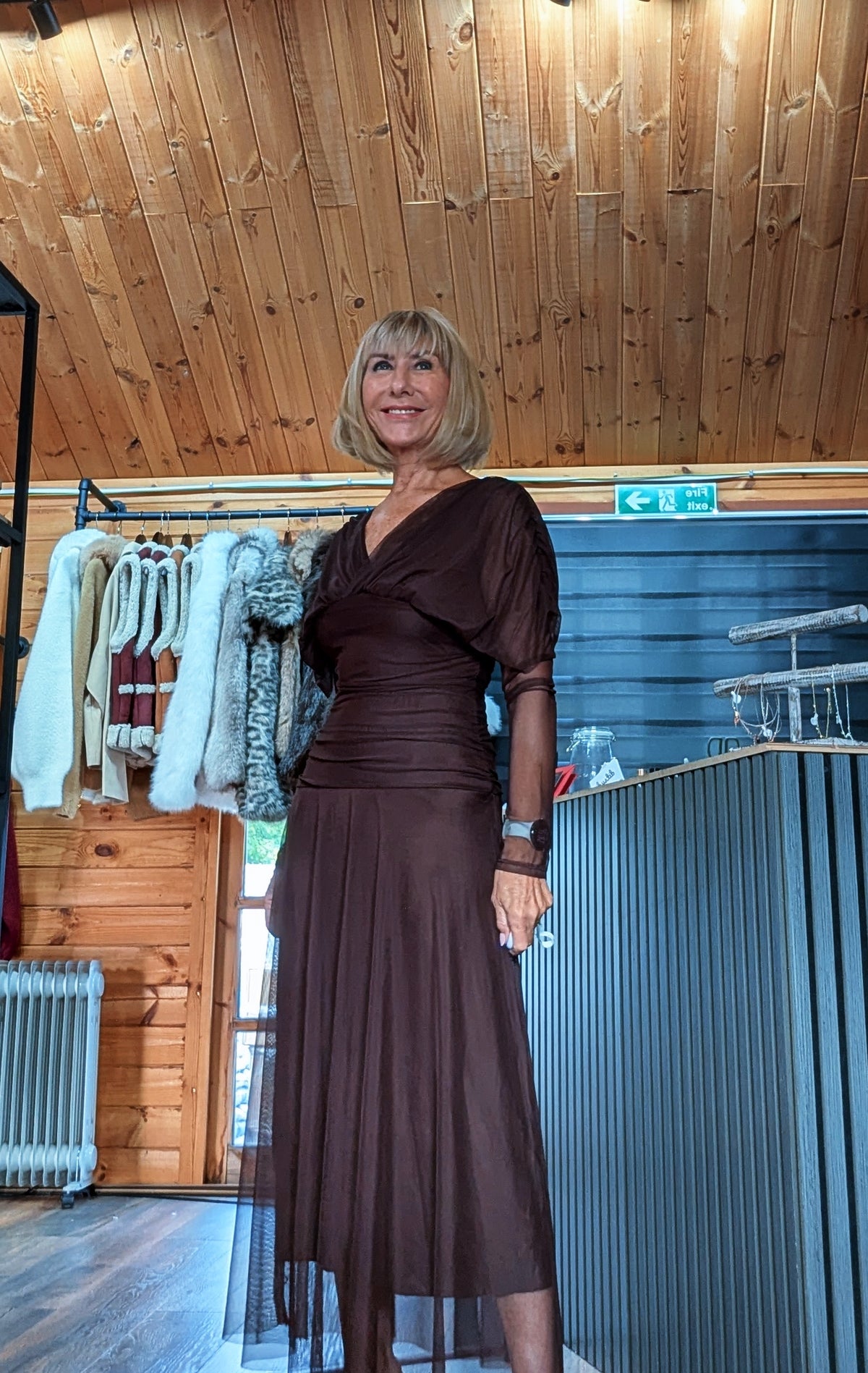 Angled view of Luna chocolate dress showing the fitted ruched waist and flowing skirt