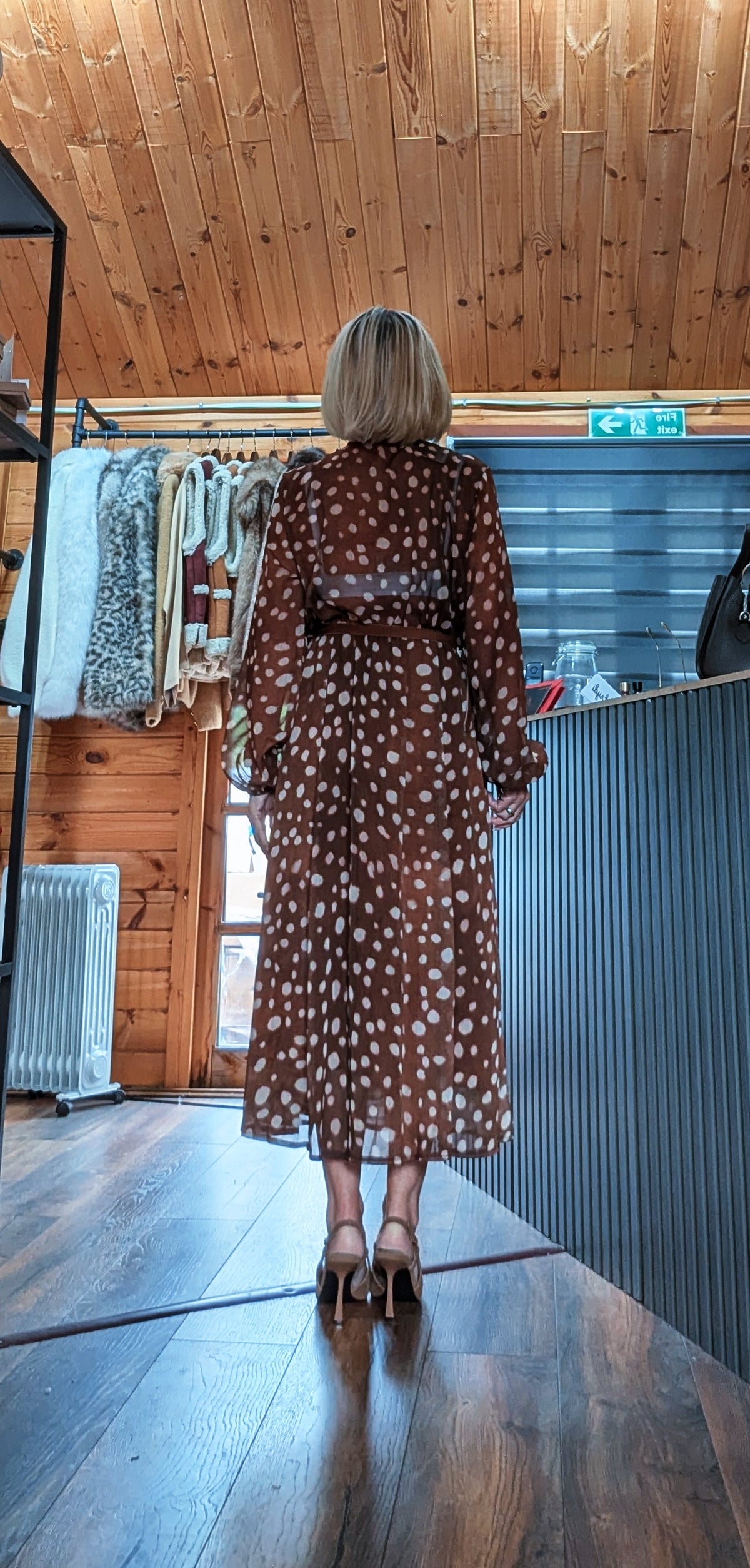 Back view of Dorothy spot-print dress showing the belted waist and flowing midi skirt
