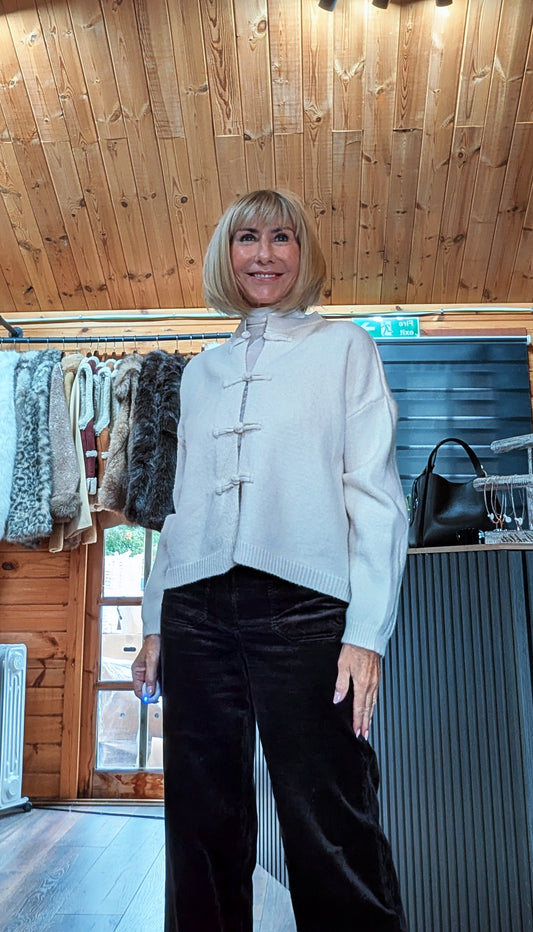 Fran cream knitted cardigan showing the decorative knot fastenings and long sleeves