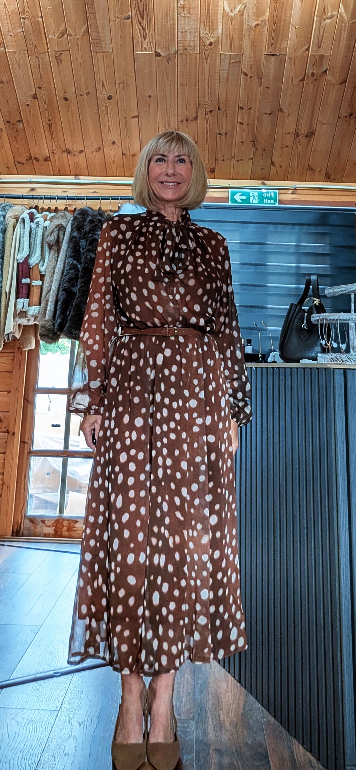 Dorothy midi dress showing its long sleeves, light spot pattern and softly flared skirt