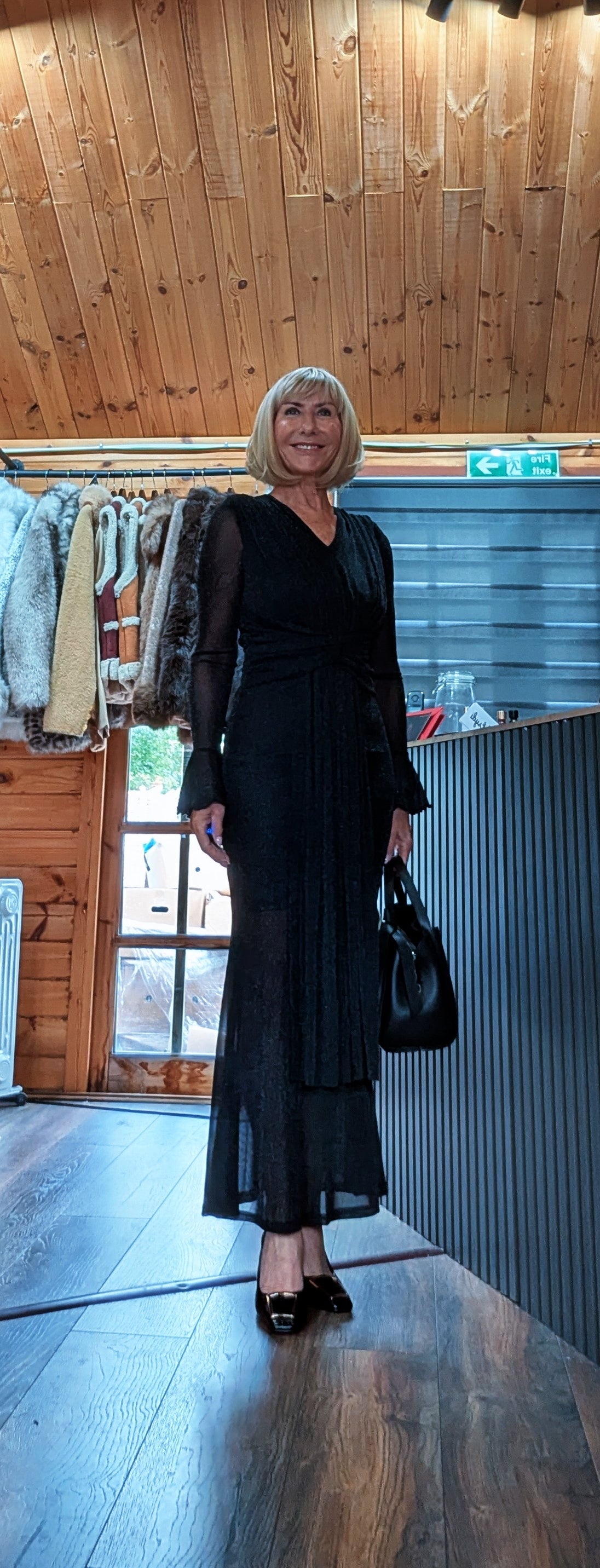 Full-length outfit with Shirley black glitter midi dress and a black handbag at the side