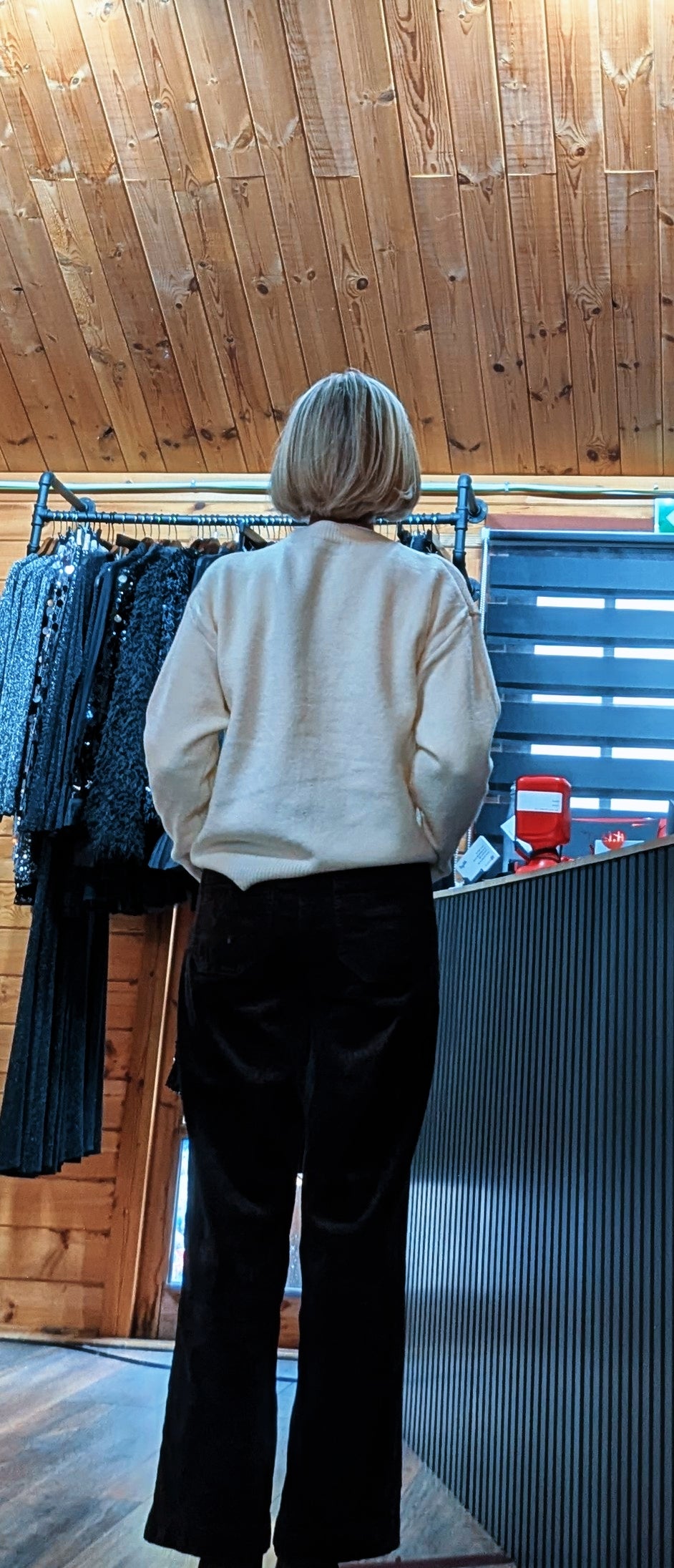 Back view of the Irene cardigan, showing its plain ivory knit and long sleeves