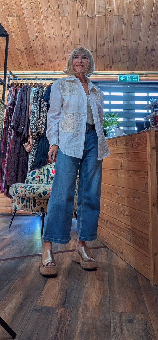  ditsydi wearing a white embroidered button-up shirt, blue wide-leg cropped jeans, and metallic gold platform sandals. 