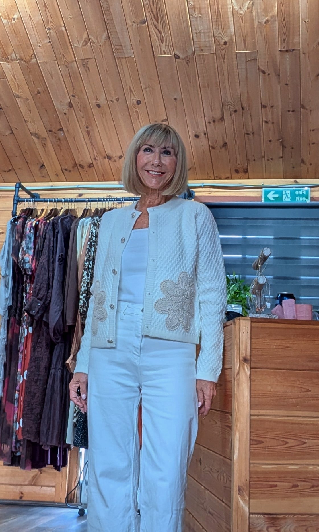 Women’s ivory knitted cardigan with decorative buttons and floral front detail.