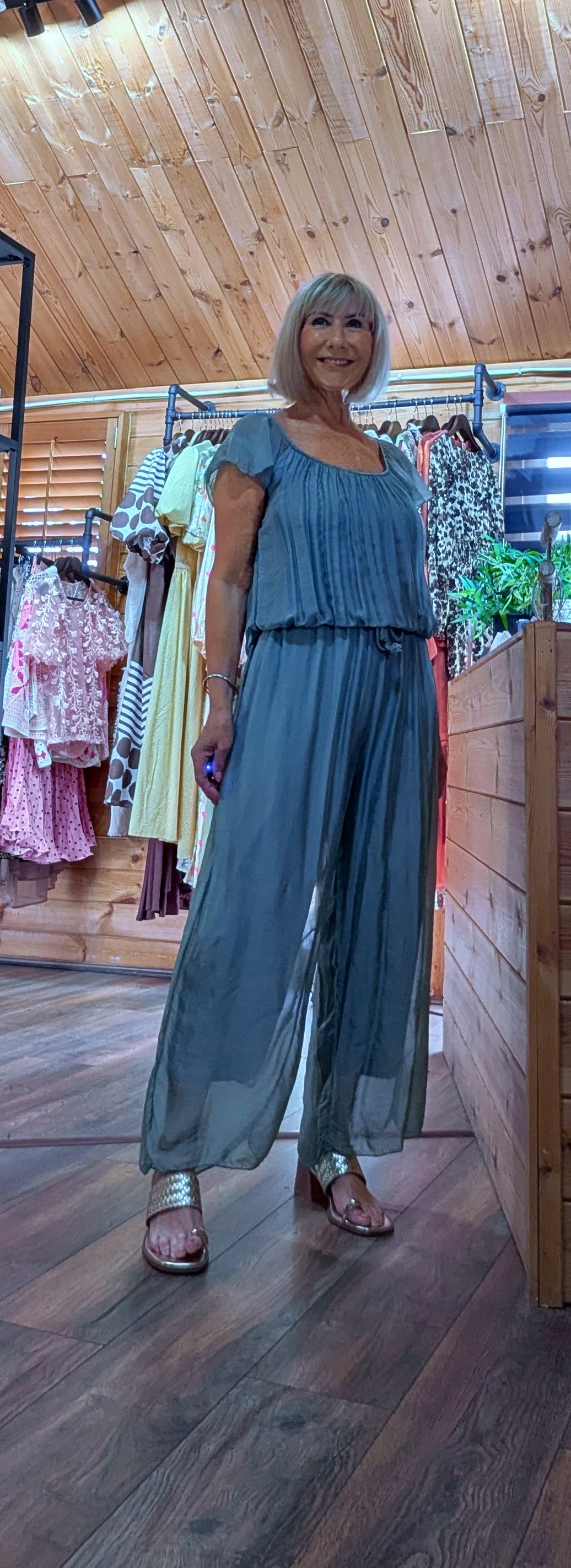 Elegant aqua silk blend jumpsuit with a versatile on or off the shoulder neckline and adjustable tie waist for a flattering fit.

