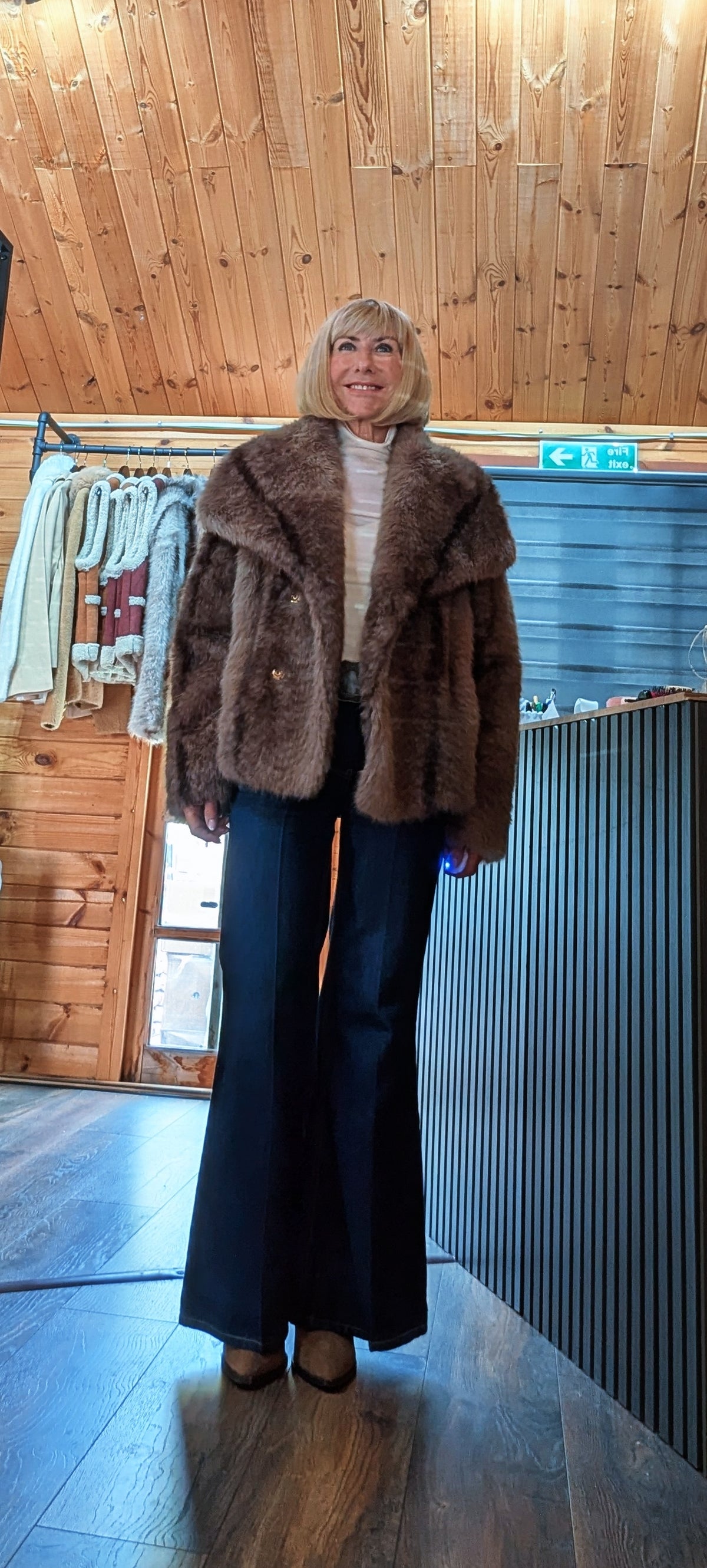 Women’s Charlotte faux-fur jacket available in taupe and chocolate brown worn with wide leg jeans