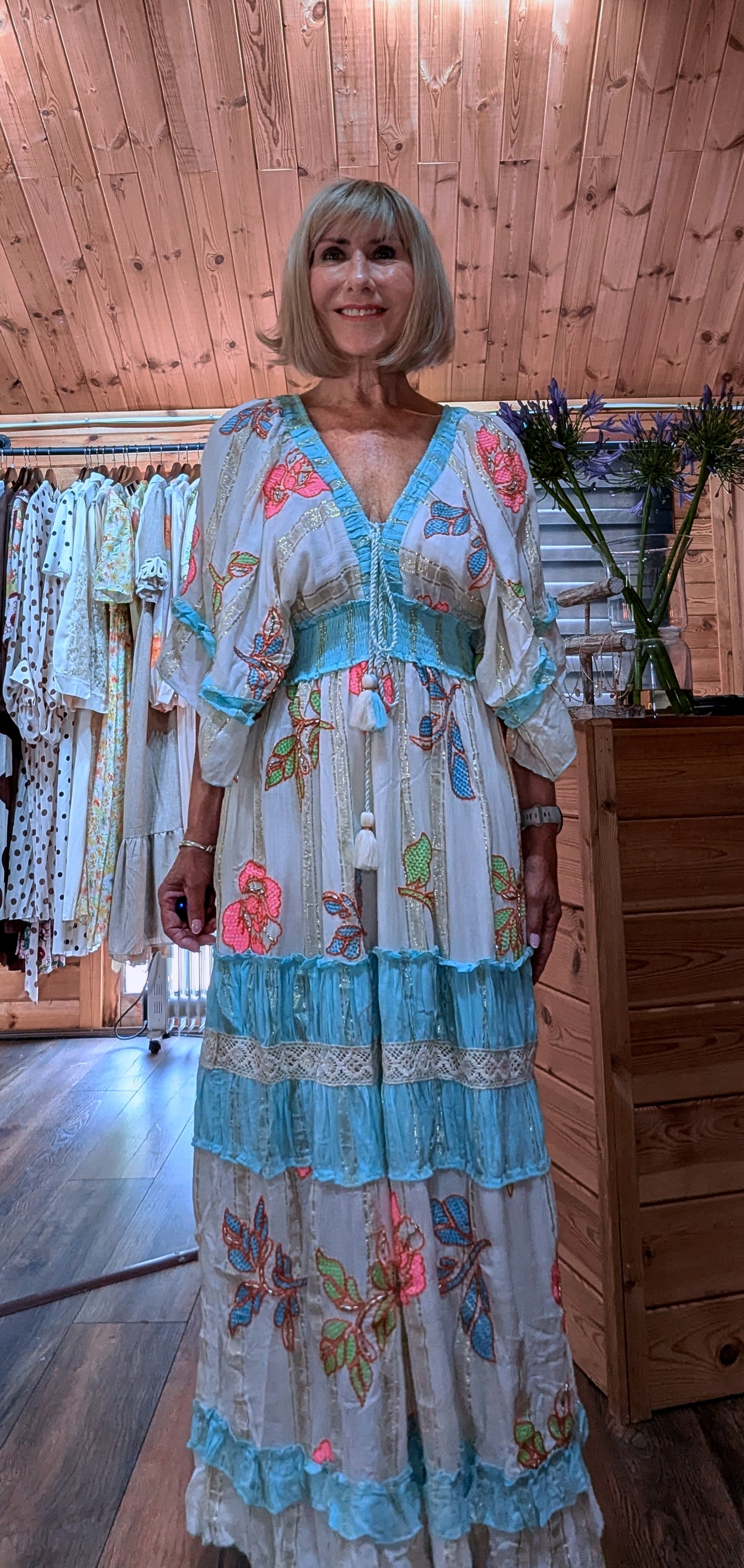 Close-up of the Lucy dress showing the V-neckline, floral print and tassel detail.