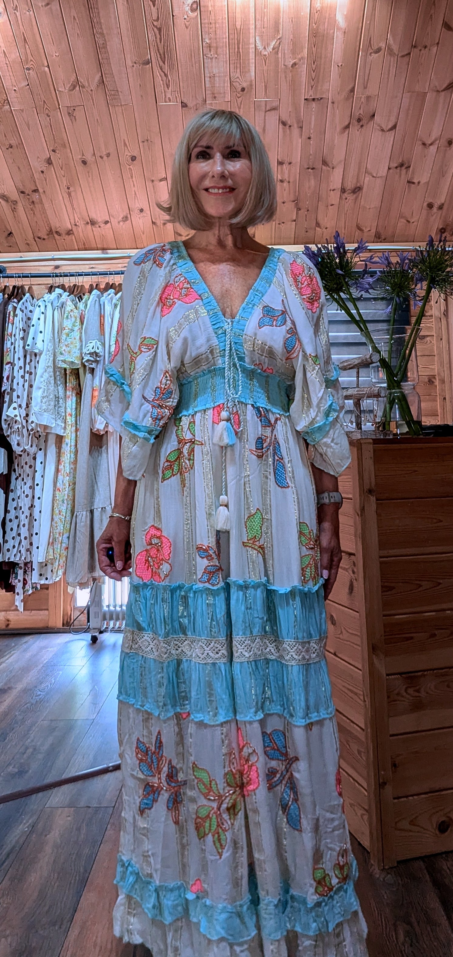 Close-up of the Lucy dress showing the V-neckline, floral print and tassel detail.