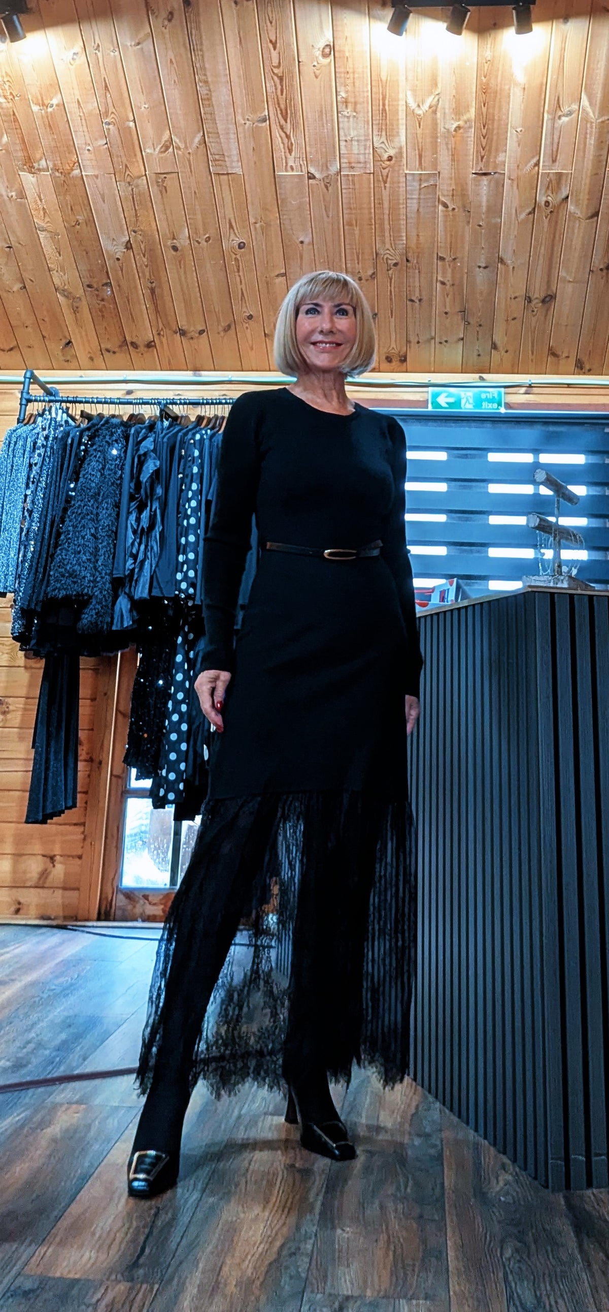 Di modelling the Aoife dress with one leg forward, showing the sheer lace hem