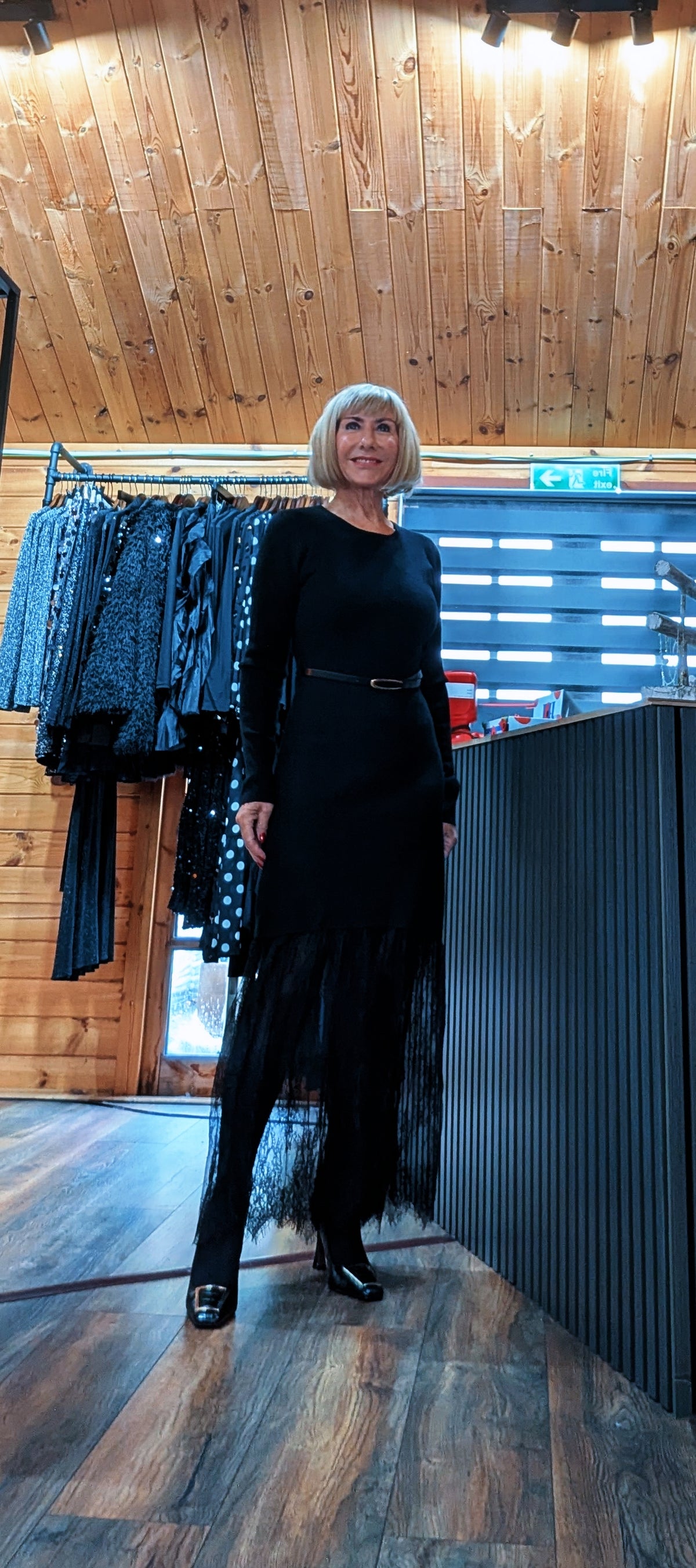 Full-length view of the Aoife black lace hem dress styled with tights and heels