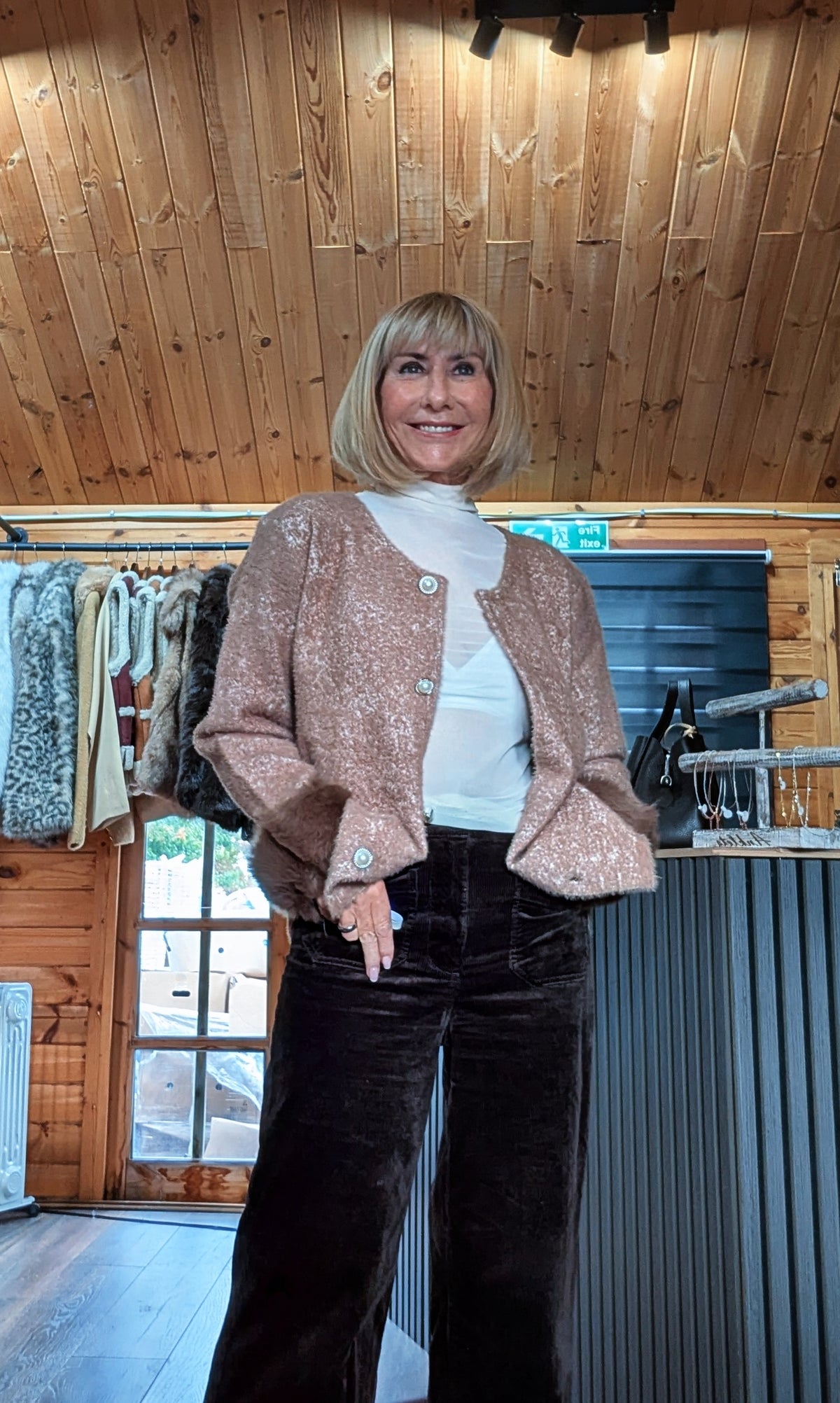 Liv chocolate cardigan worn open over a white high-neck top, showing decorative buttons and faux fur cuffs