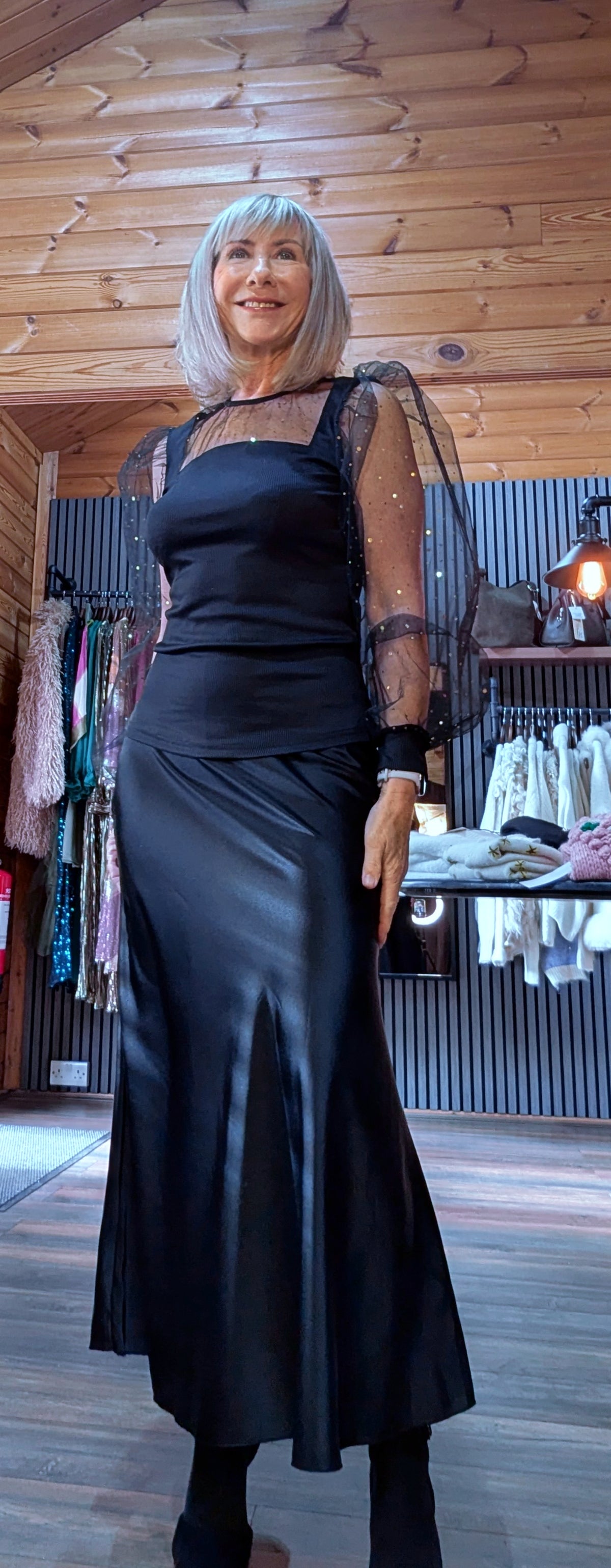 Sia black sparkle top with sheer organza sleeves, styled with a black midi skirt