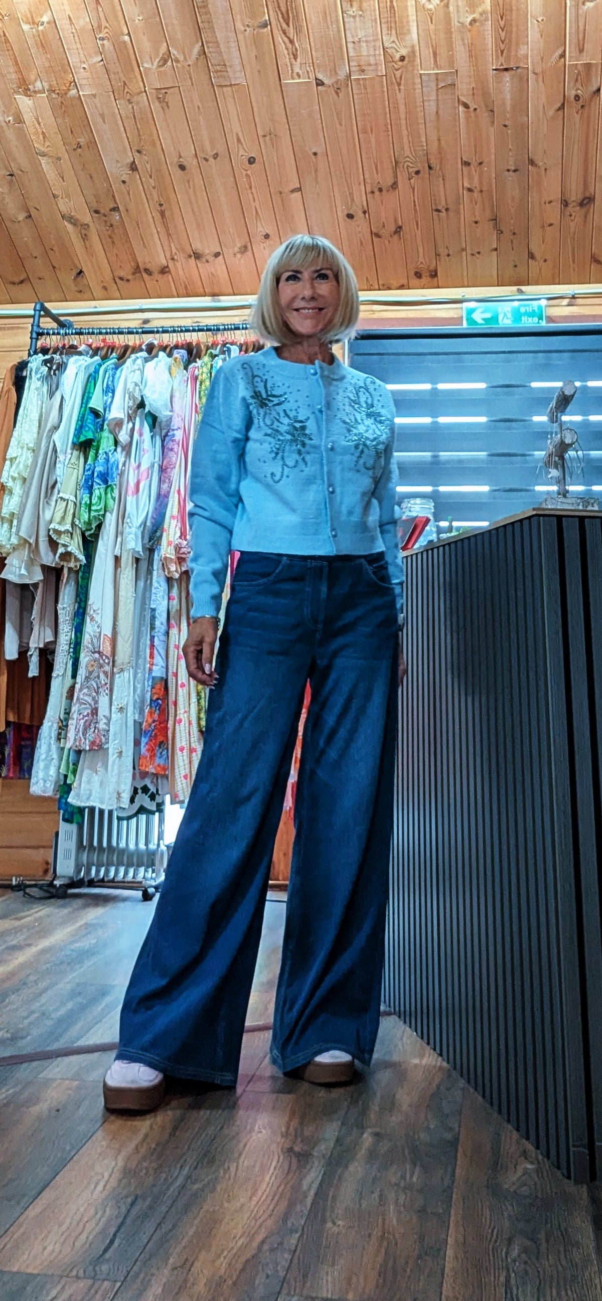 ditsydi wearing wide leg jeans and a light blue fitted cardigan with intricate embroidery and beading