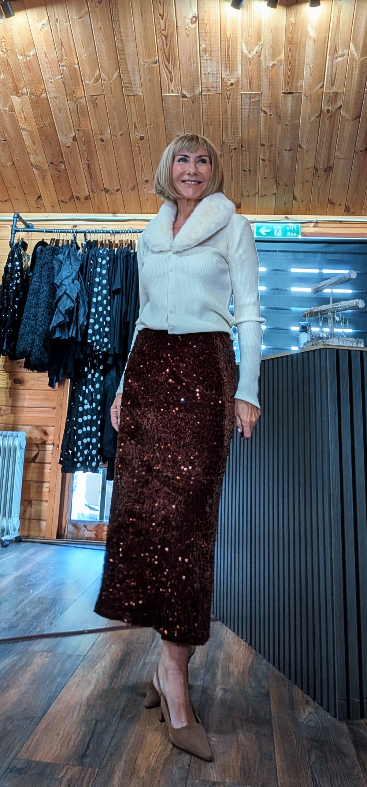 Three-quarter view of Astrid sequin midi skirt styled with neutral pointed heels