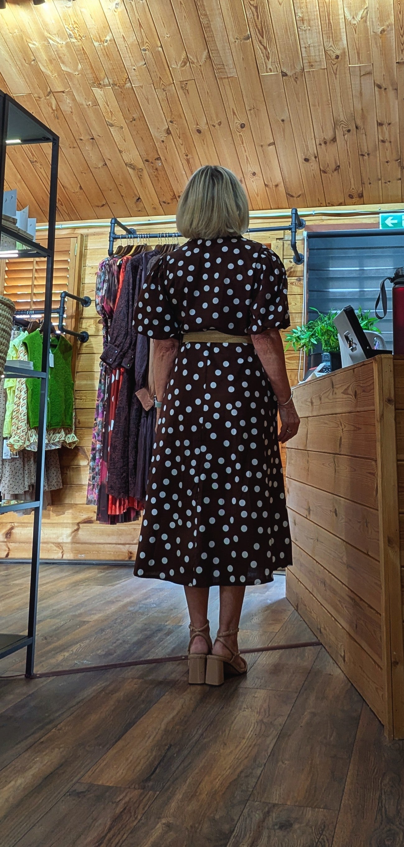 Rear view of the Aoife brown and white spotted dress with a feminine flowing shape.