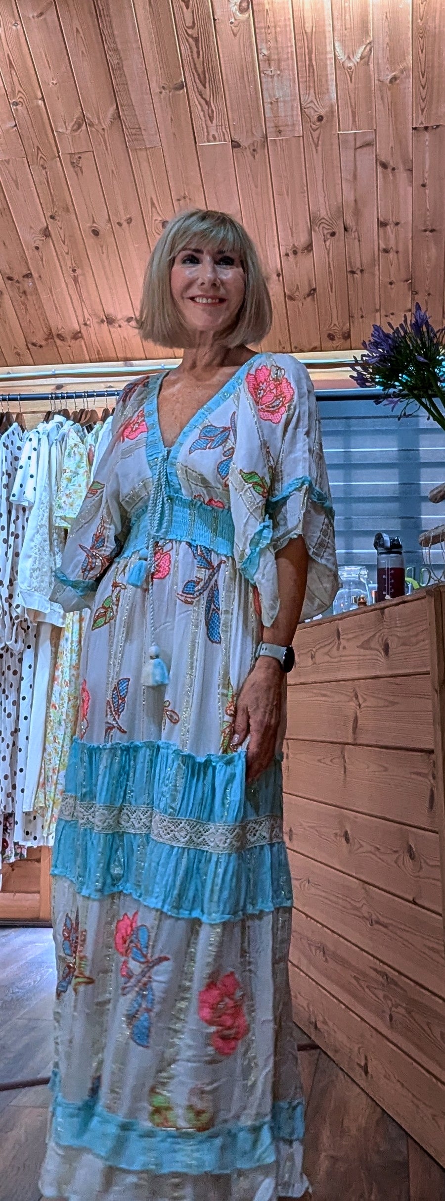 Lucy floral V-neck maxi dress with turquoise tiered trim and flowing sleeves.