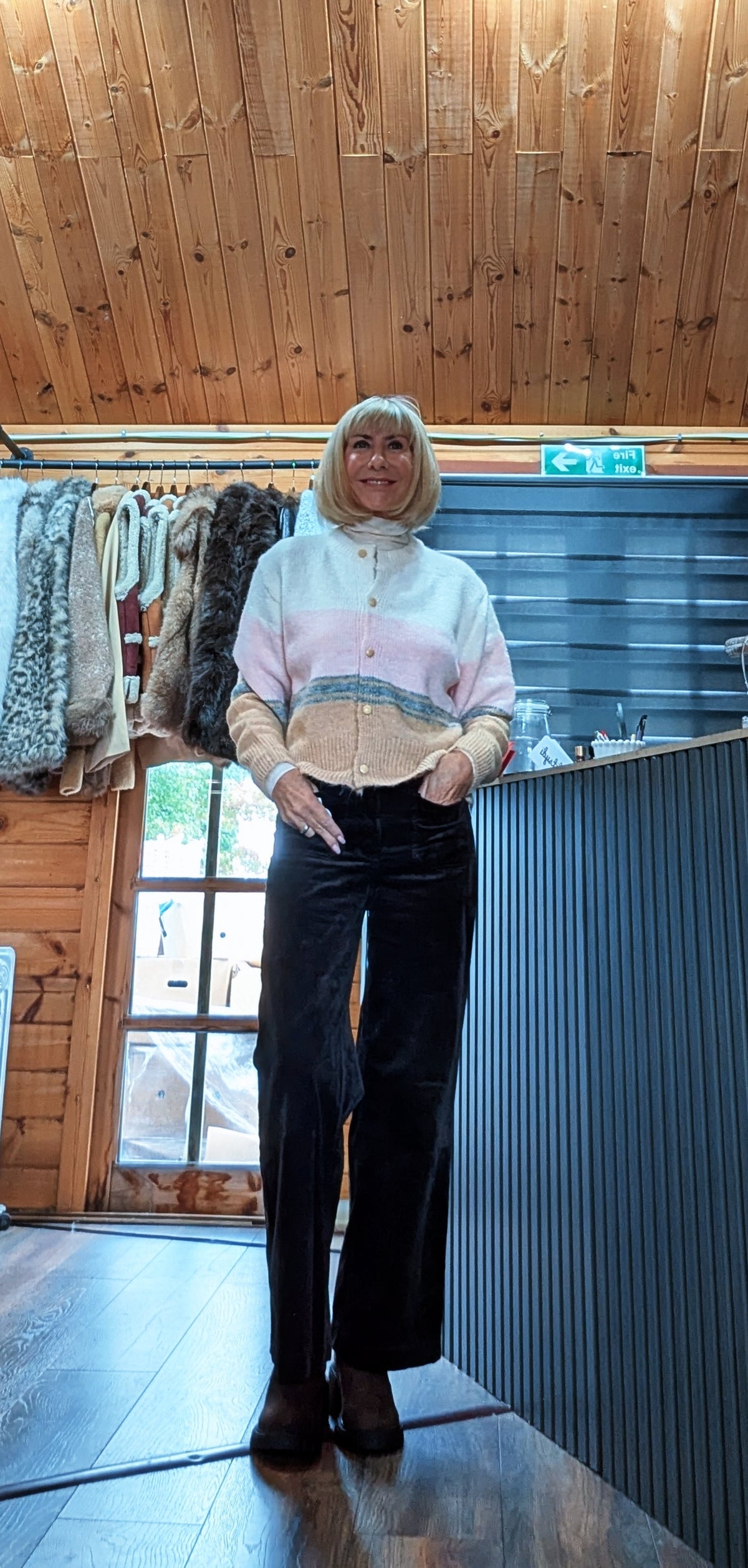 Relaxed front view of Helen colour block cardigan with one hand in a trouser pocket