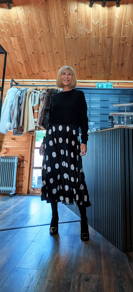 Di wearing the Hettie black midi dress with a knitted top and pleated skirt with large white spots.