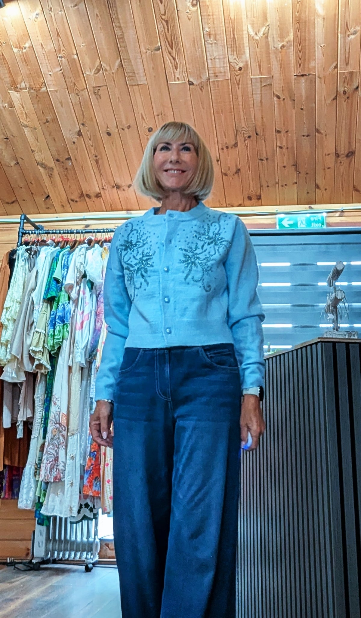 Front view of light blue cardigan with glossy buttons and beading 