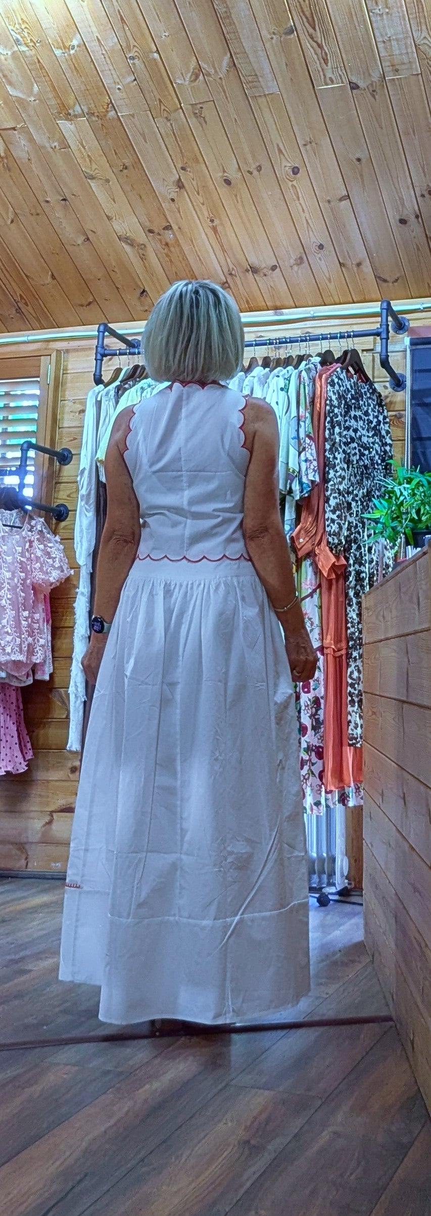 Rear  view Model wearing the Iris white cotton top and skirt co-ord,  embroidered two-piece outfit perfect for holidays, garden parties and summer occasions.