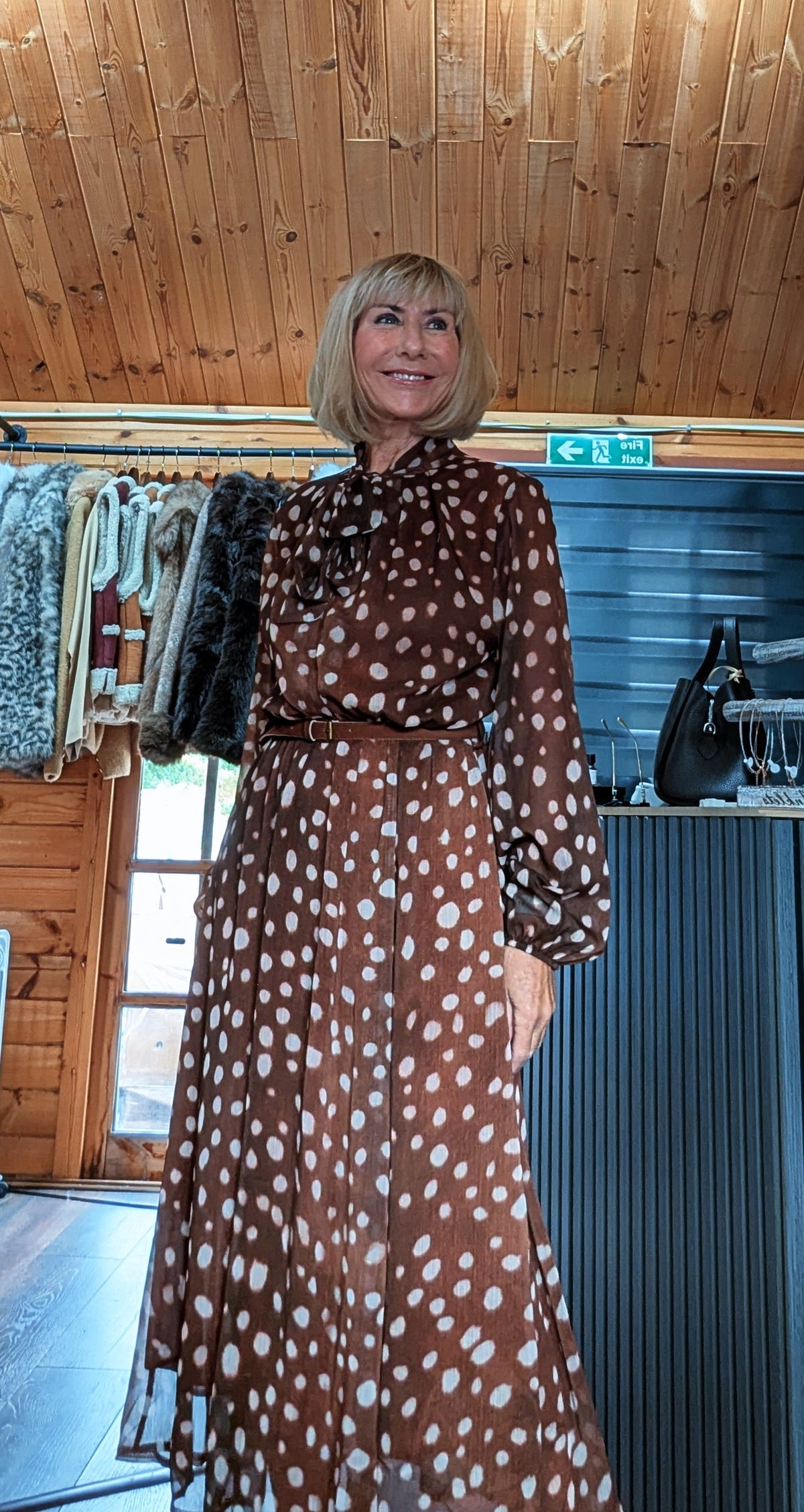 Angled view of Dorothy tie-neck dress showing the gathered sleeve cuffs and belt