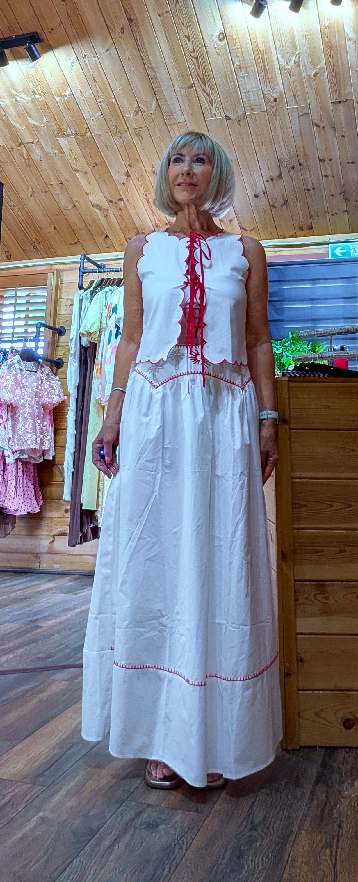 Full-length view of the Iris white cotton co-ord featuring a sleeveless embroidered top and flowing maxi skirt with contrasting red trim.