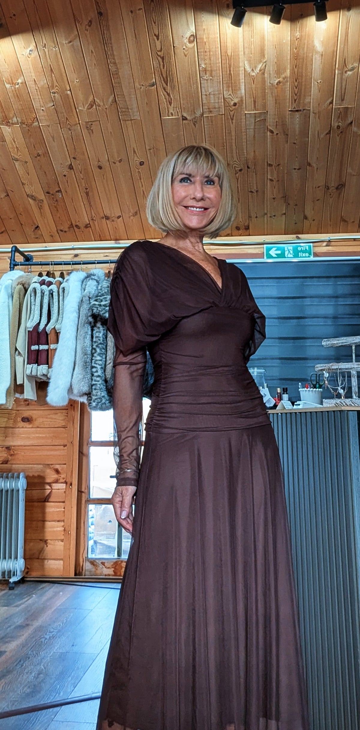 Detail view of Luna chocolate dress showing the draped neckline and sheer sleeves