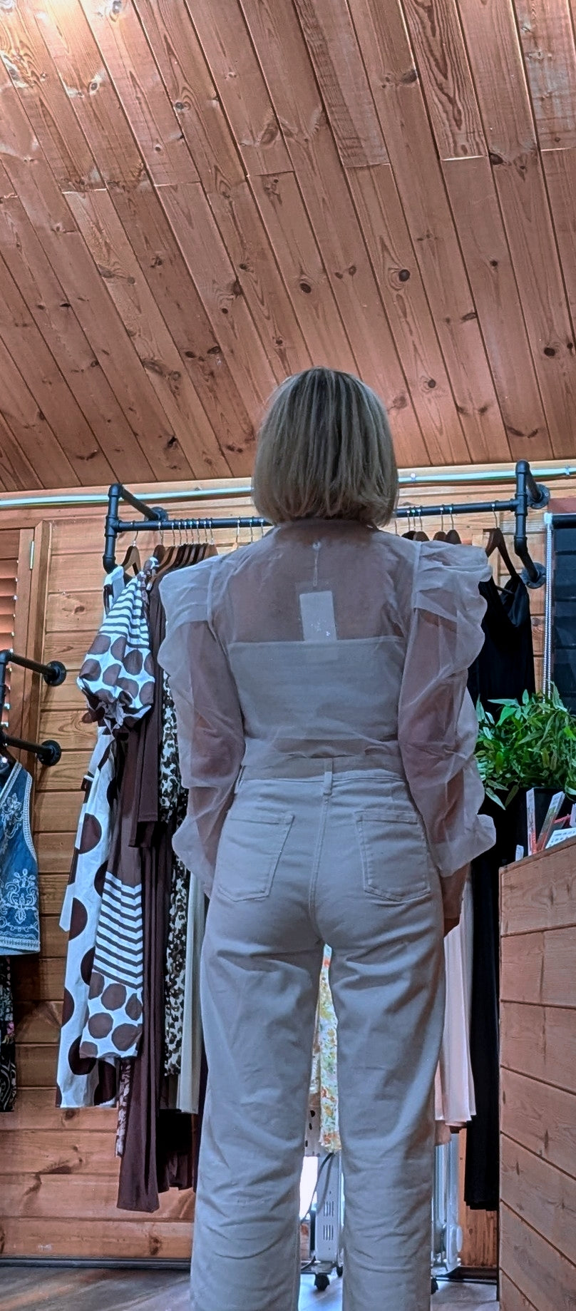 Back of ditsydi wearing the Lucille  white puff-sleeve blouse with tailored  white trousers.